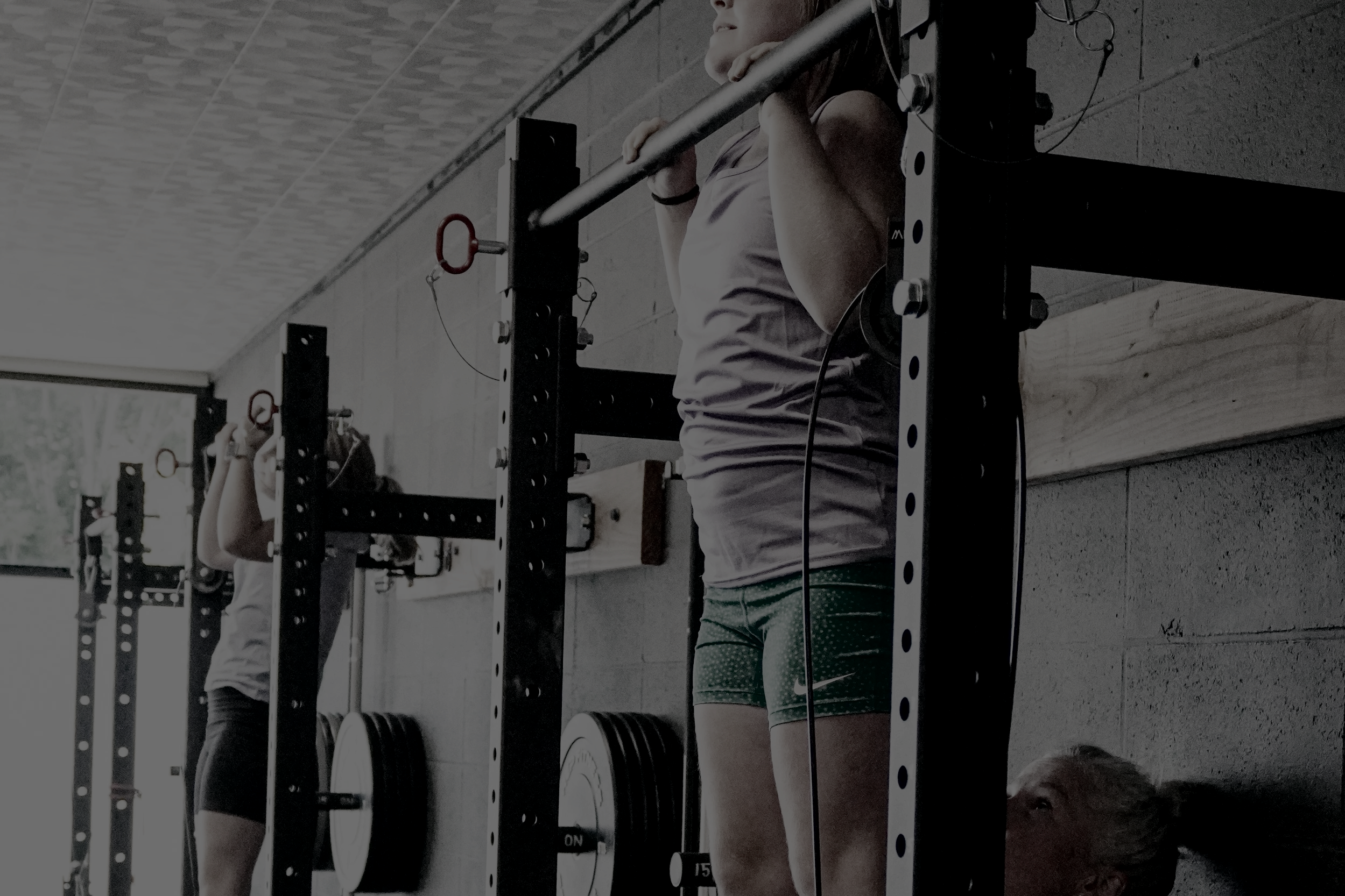 girl holding herself up on pull up bar at a womans only gym