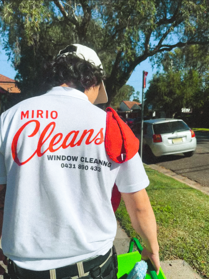Mirio Cleans window cleaner wearing a branded work uniform.