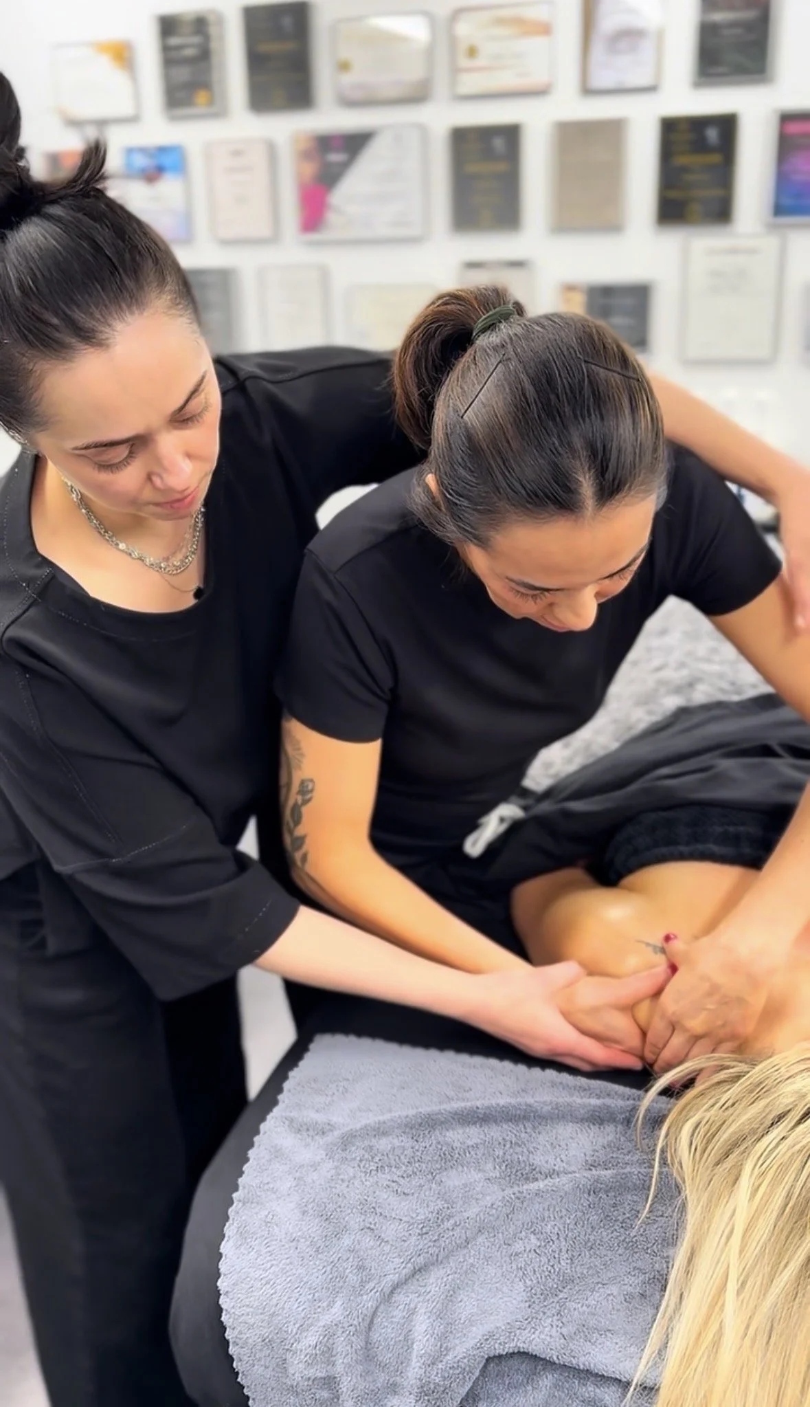Advanced facial massage training with an instructor guiding a student during a hands-on workshop in Denver, Colorado.