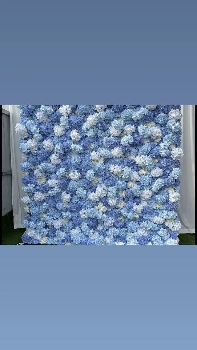 A wall covered with a dense arrangement of blue and white hydrangea flowers.