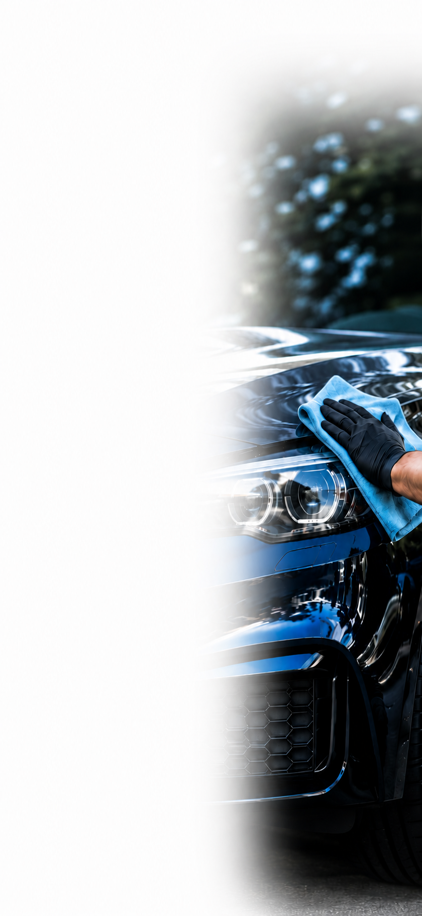 A person wearing black gloves cleaning the hood of a black car with a blue cloth.
