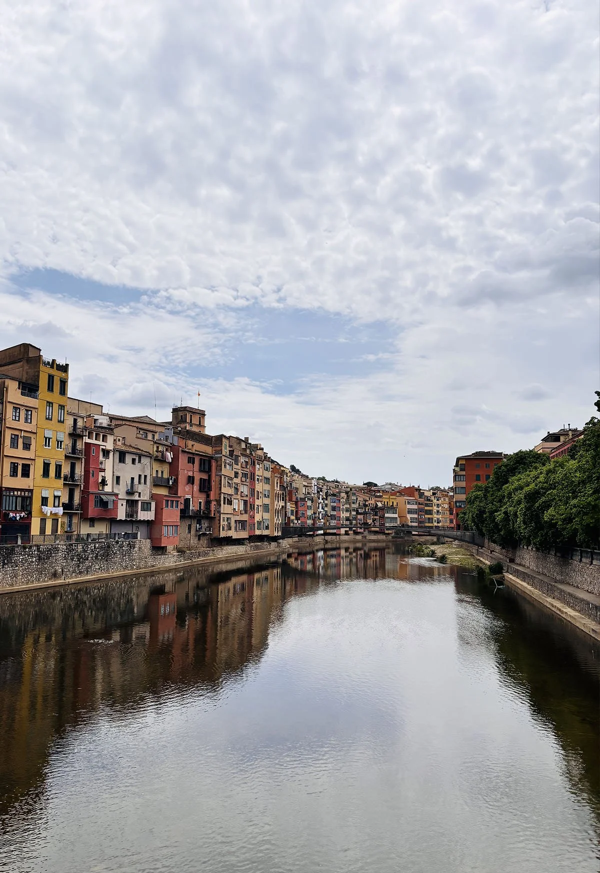 Colorful buildings lining a canal under a cloudy sky.