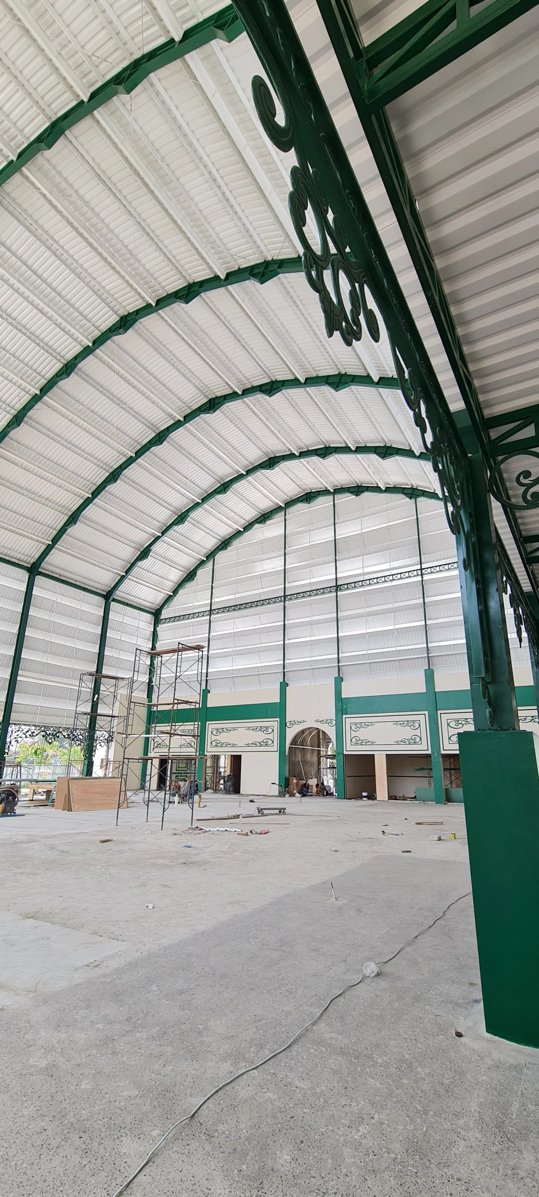 Interior of a large building under construction with a high arched ceiling and our white UPVC roof and cladding.