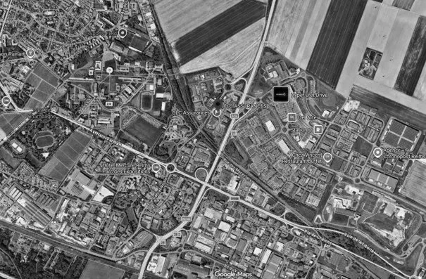 Carte satellite d'une zone urbaine avec routes, bâtiments et champs agricoles environnants.