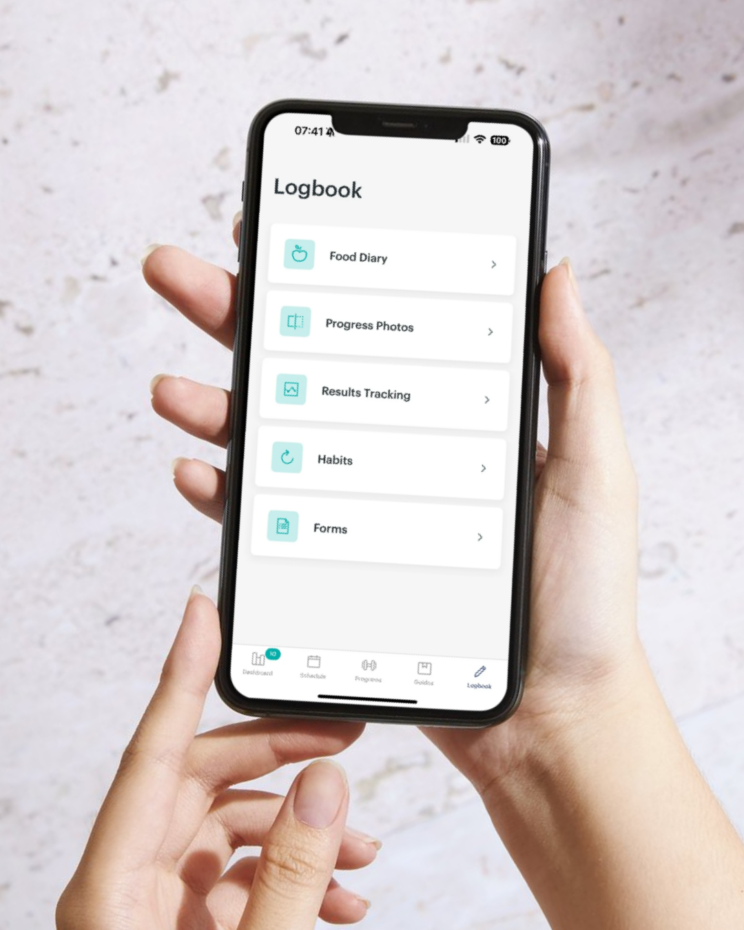 Een persoon houdt een smartphone vast met een app geopend op het scherm, tonen de onderdelen van een logboek zoals Food Diary, Progress Photos, Results Tracking, Habits en Forms, tegen een lichte, textured achtergrond.