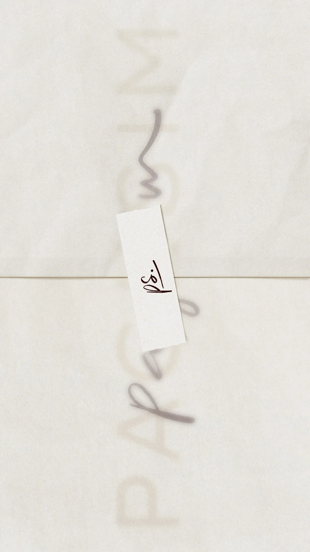 A white strip of paper folded in half with handwritten text that says 'p.s' on a piece of tape, stuck to beautiful stationary with cursive writing saying 'pagesim'.