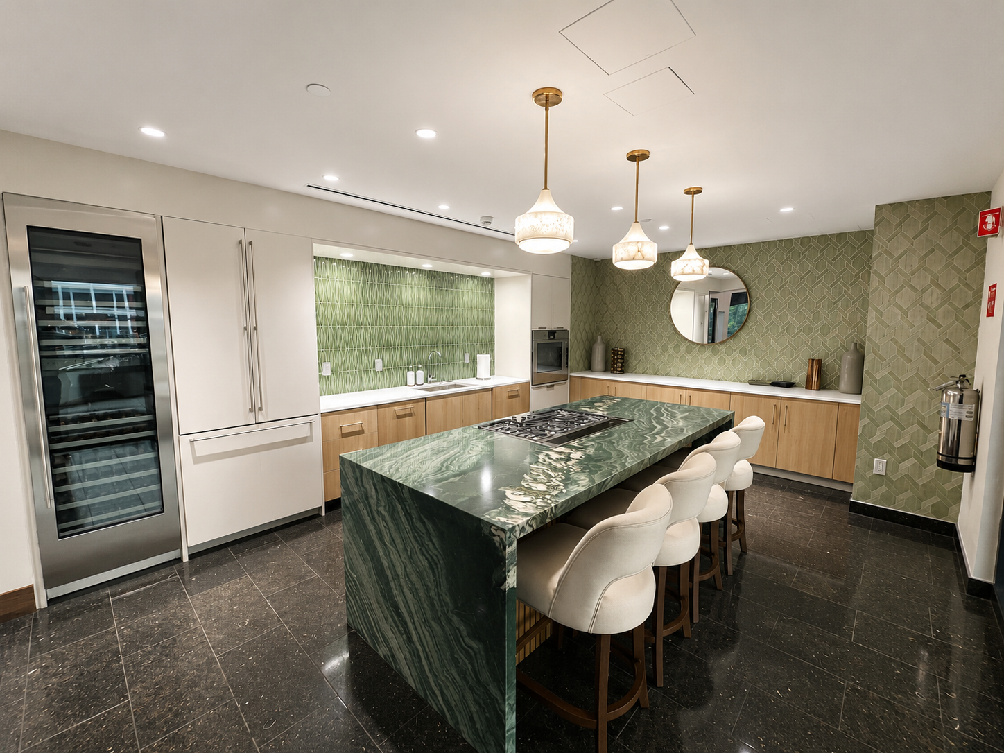 Modern kitchen with green and white color scheme, featuring a large green marble island with seating, green patterned backsplash, white cabinetry, built-in oven, and pendant lights.