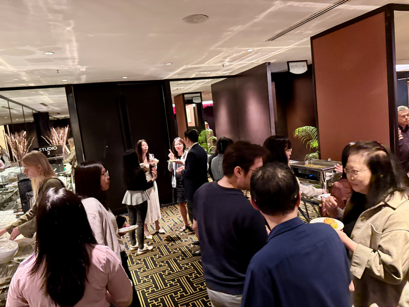 Group of people socializing at a buffet table in a restaurant or event space.