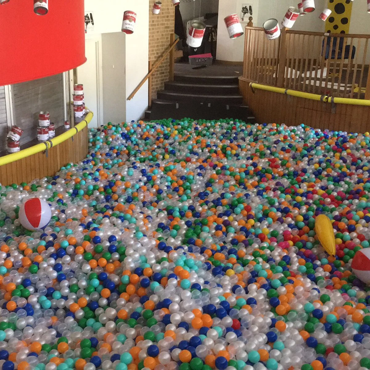 Multicoloured ball pit room fill covering the floor of a bar beneath a staircase