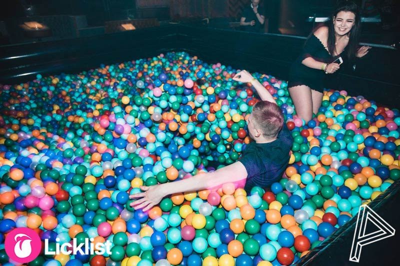 Guests playing in a multicoloured ball pit at a nightclub event