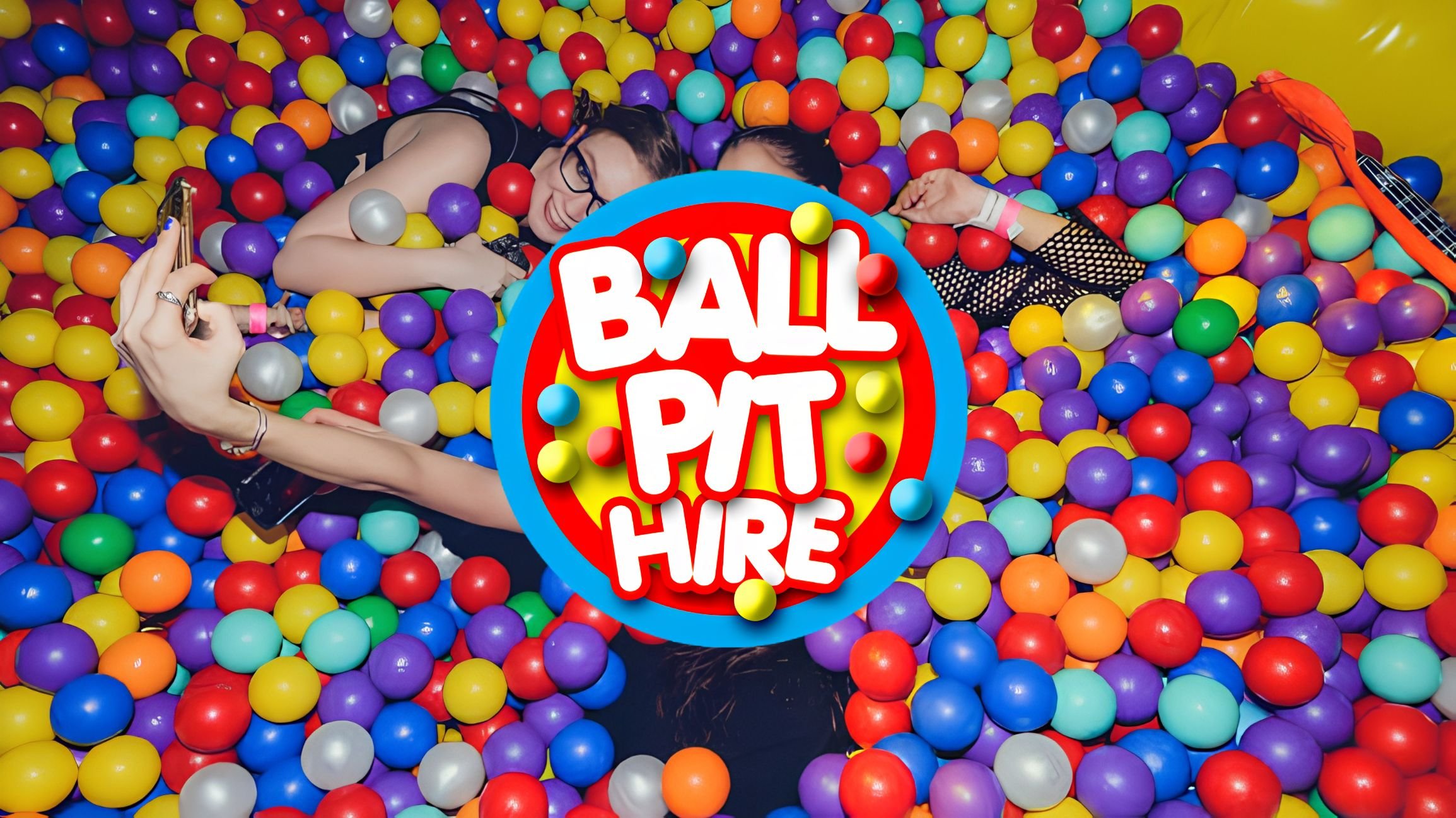 Guests lying in a giant multicoloured ball pit with the Ball Pit Hire logo