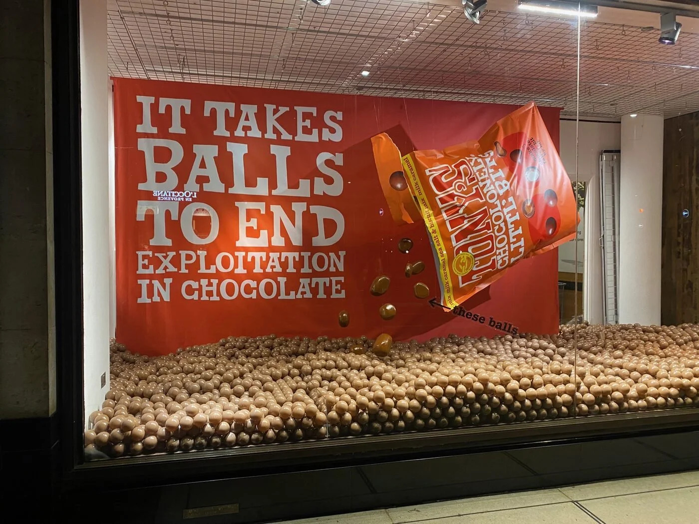 Tony's Chocolonely campaign window filled with chocolate-coloured balls - It takes balls to end exploitation in chocolate