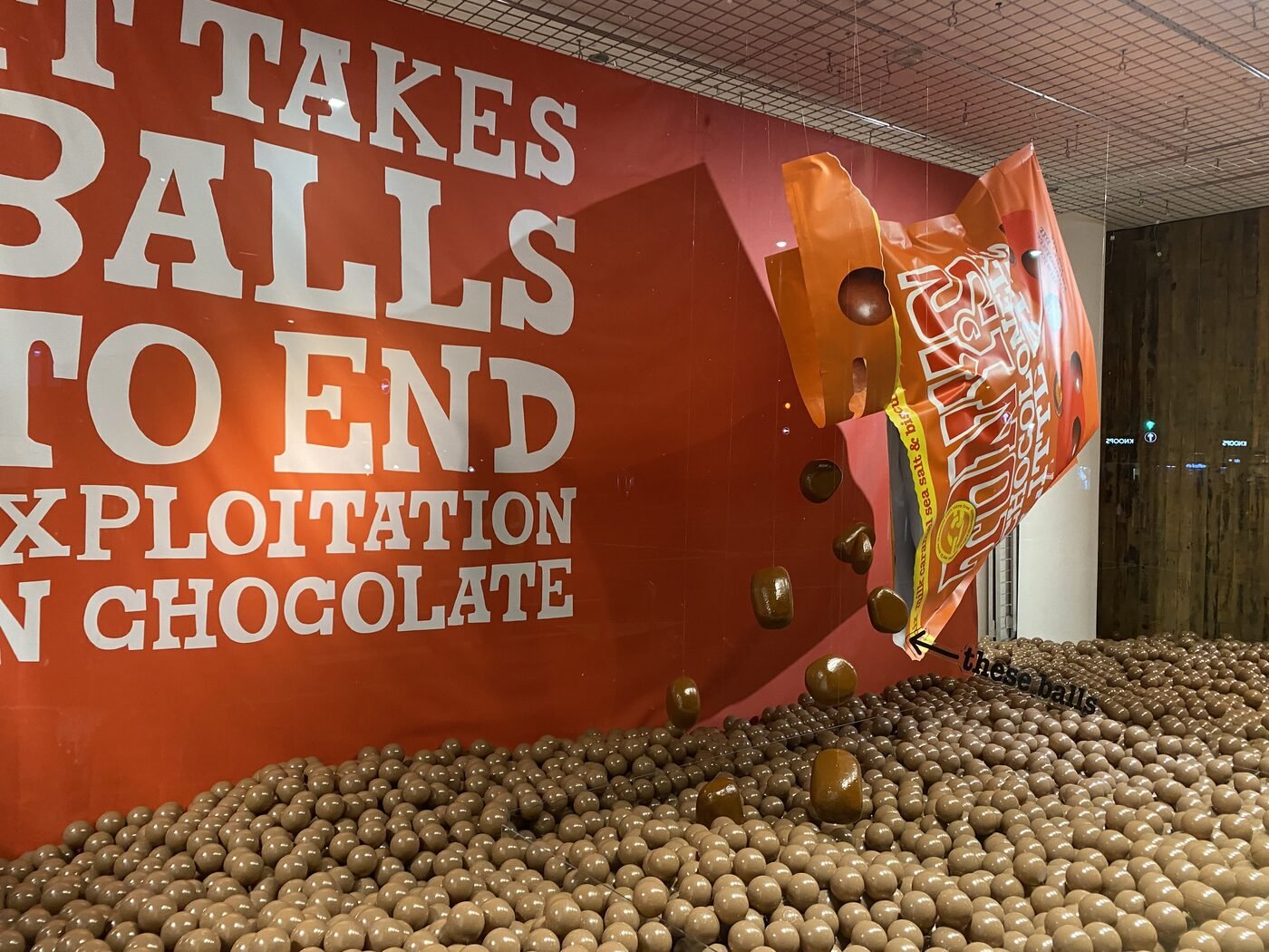 Giant Tony's Chocolonely bag pouring chocolate-coloured balls into the window display