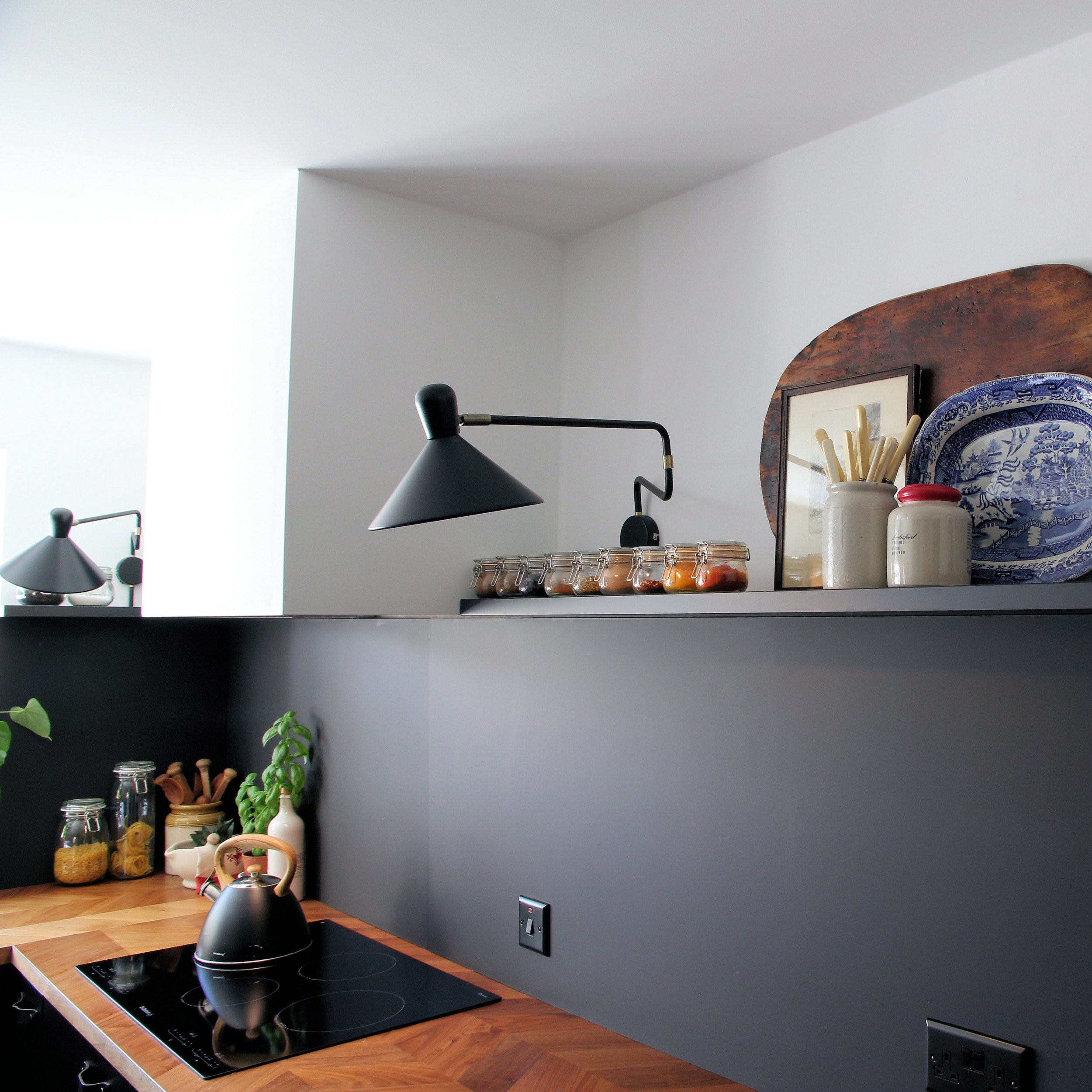 Detail of Black laminated kitchen with Walnut worktops.