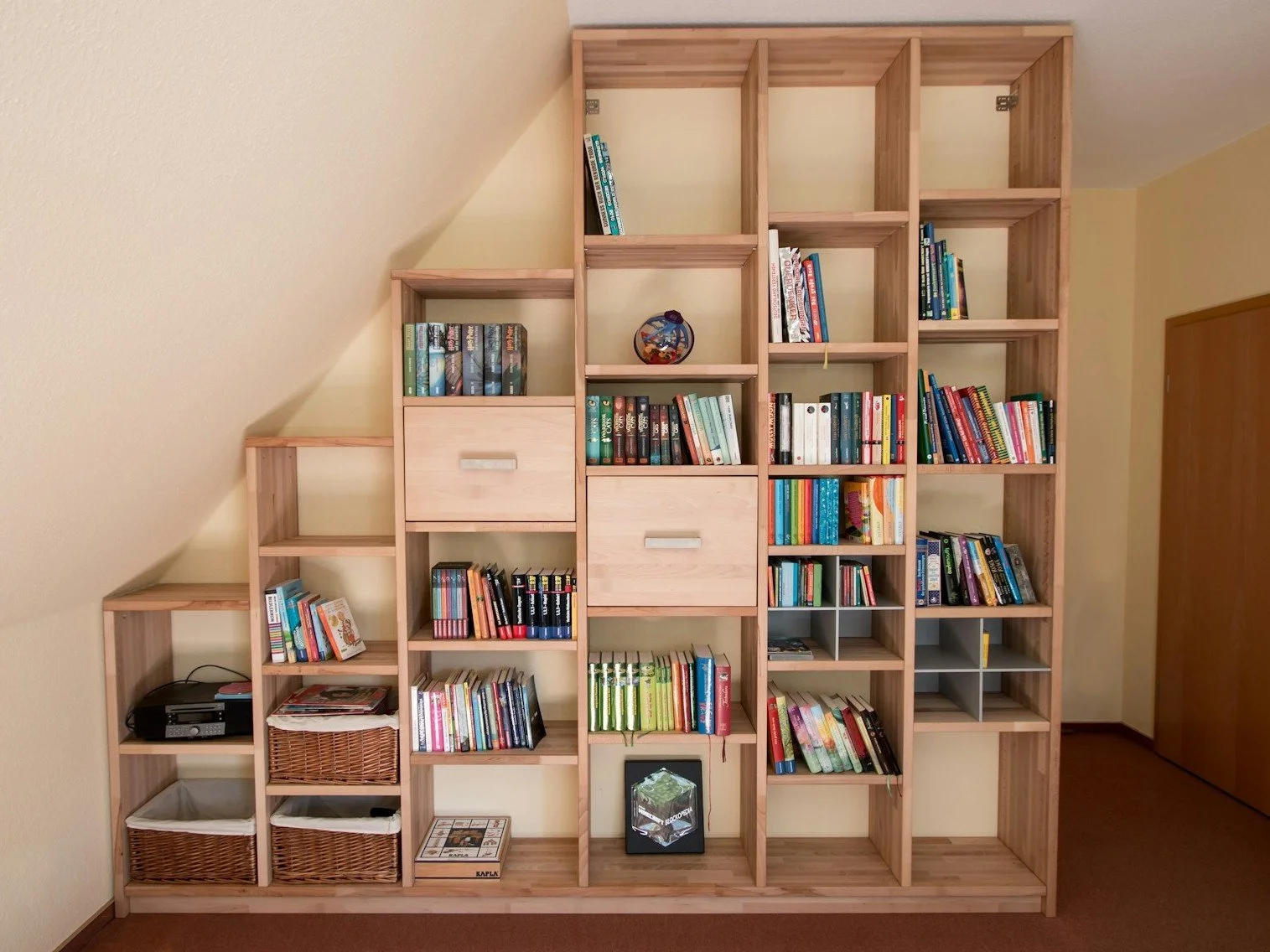 Shelving unit fitted under sloping ceiling.
