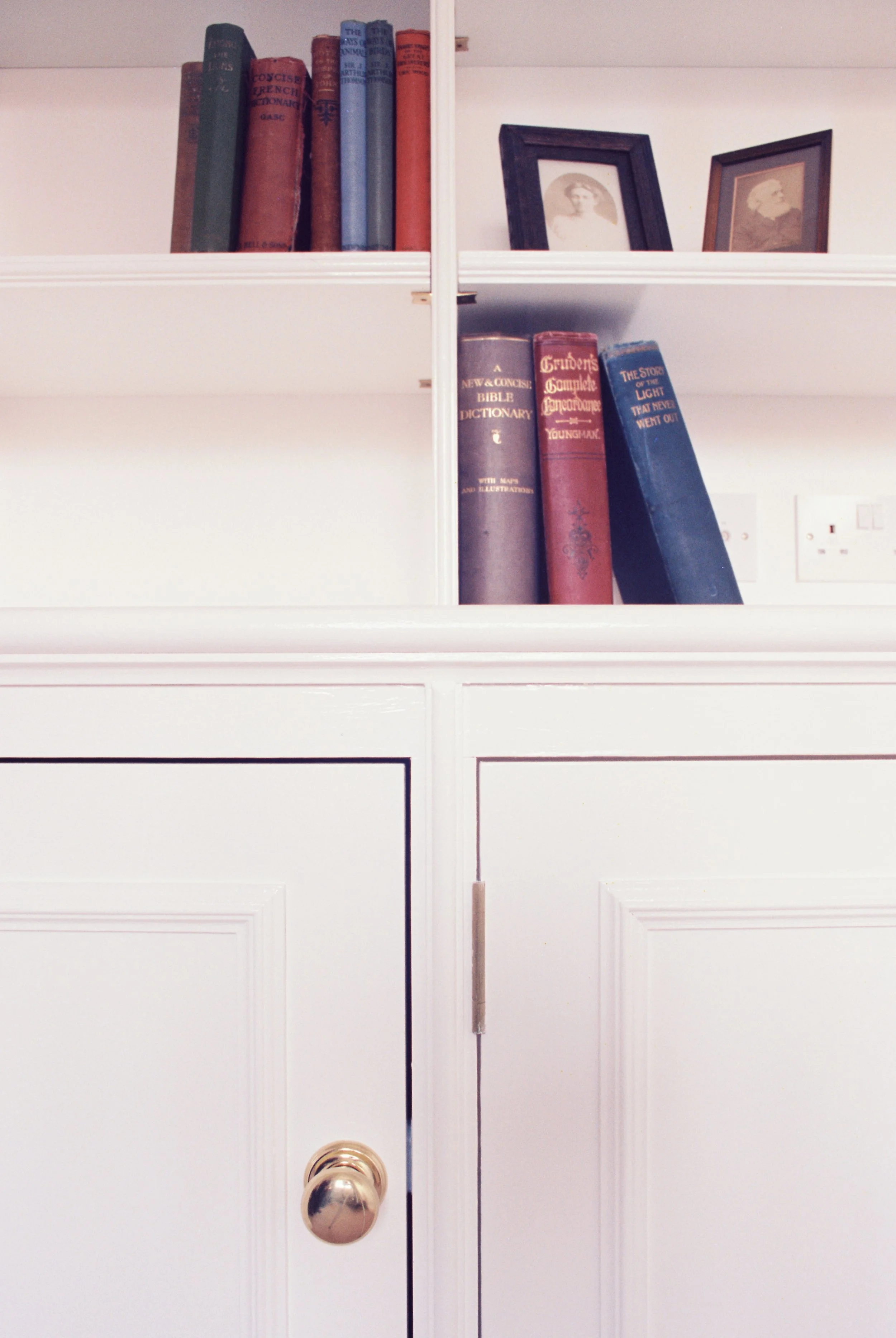 Detail of White painted built-in cupboard/bookcase.