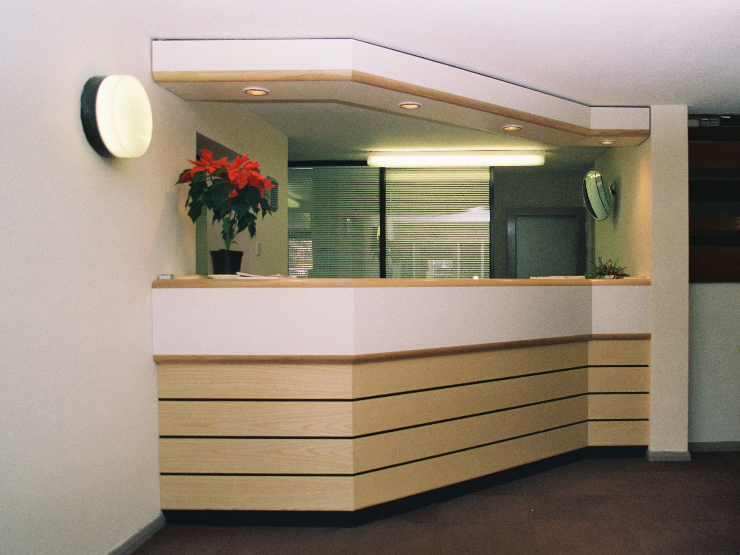 Bespoke, reception desk in Doctor's Surgery featuring natural Ash timber and White laminated surfaces.