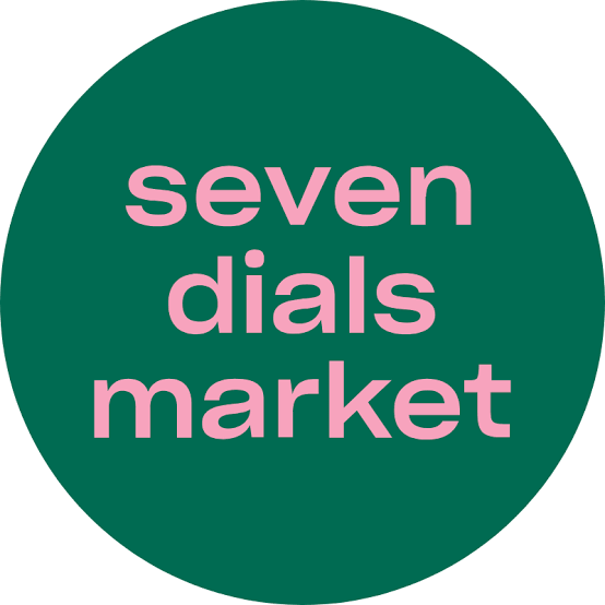 Green circular logo with pink text that reads 'seven dials market.'