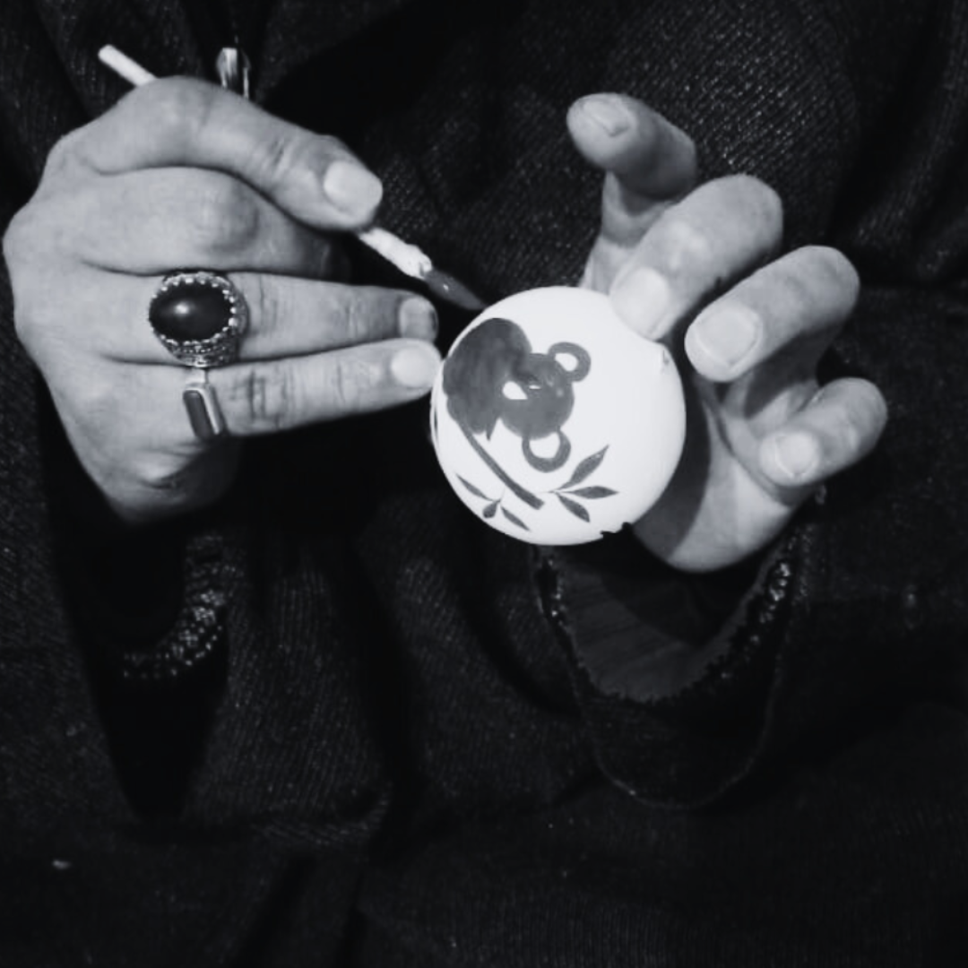 Artist holding a bauble and painting on it