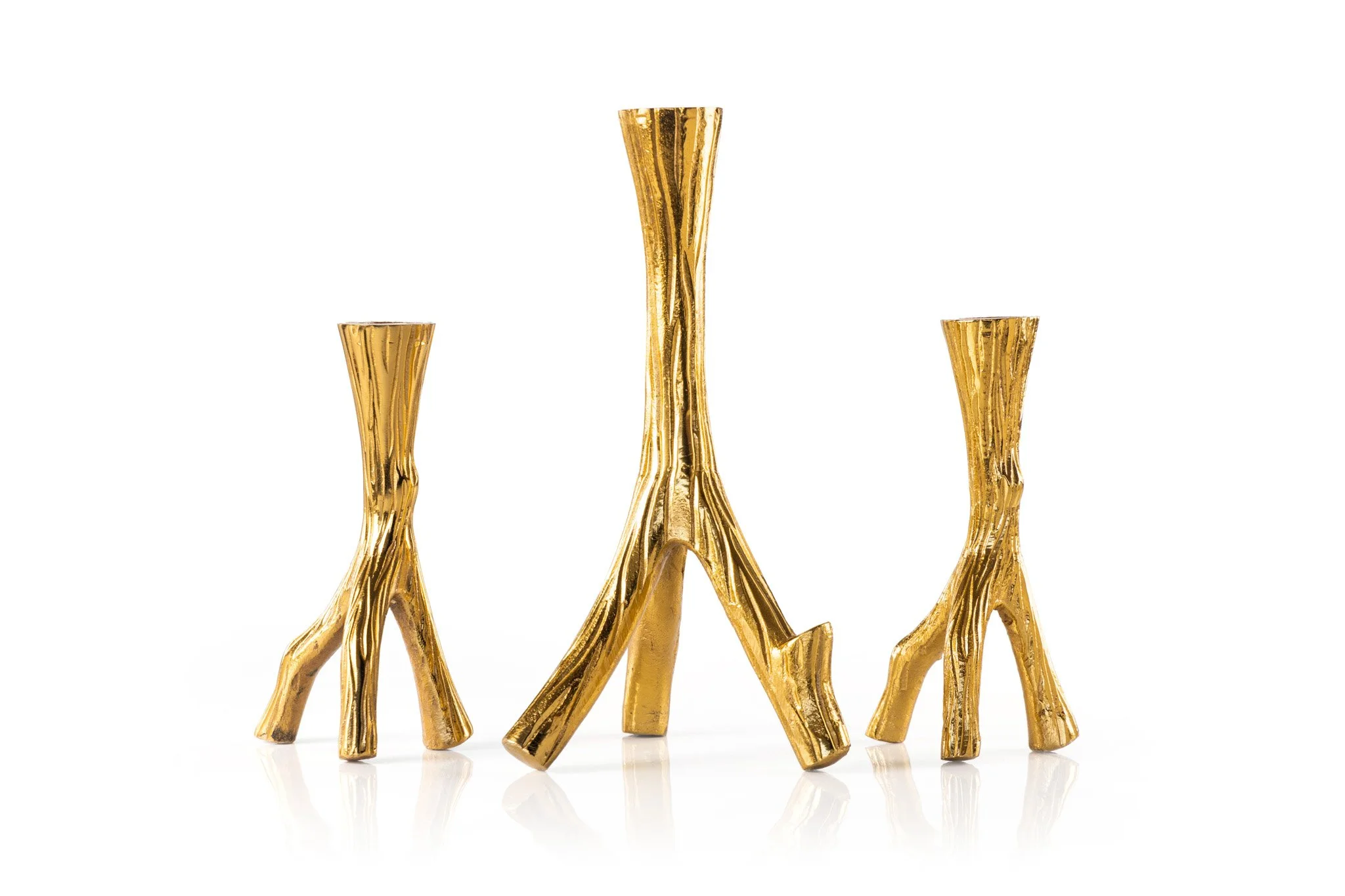 A collection of gold candle stands in a row against a white background.