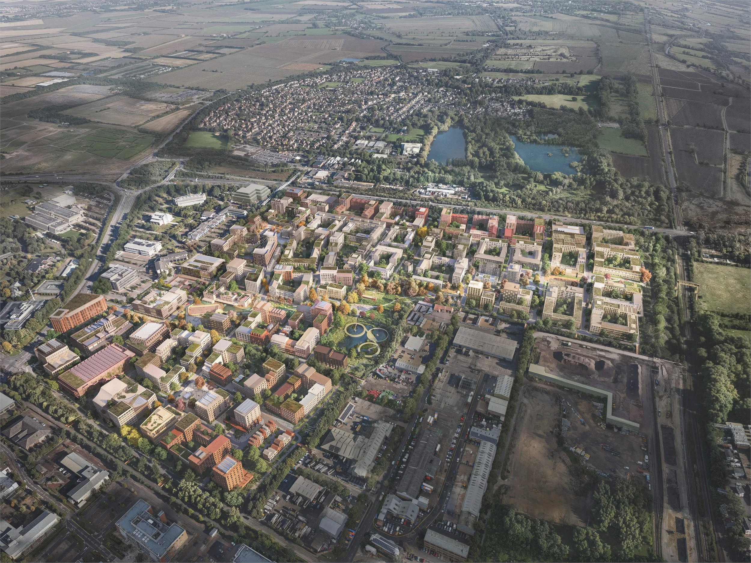 An aerial view of a new part of a city with a mix of modern and older buildings, green parks, and a large pond, surrounded by farmland and open fields.