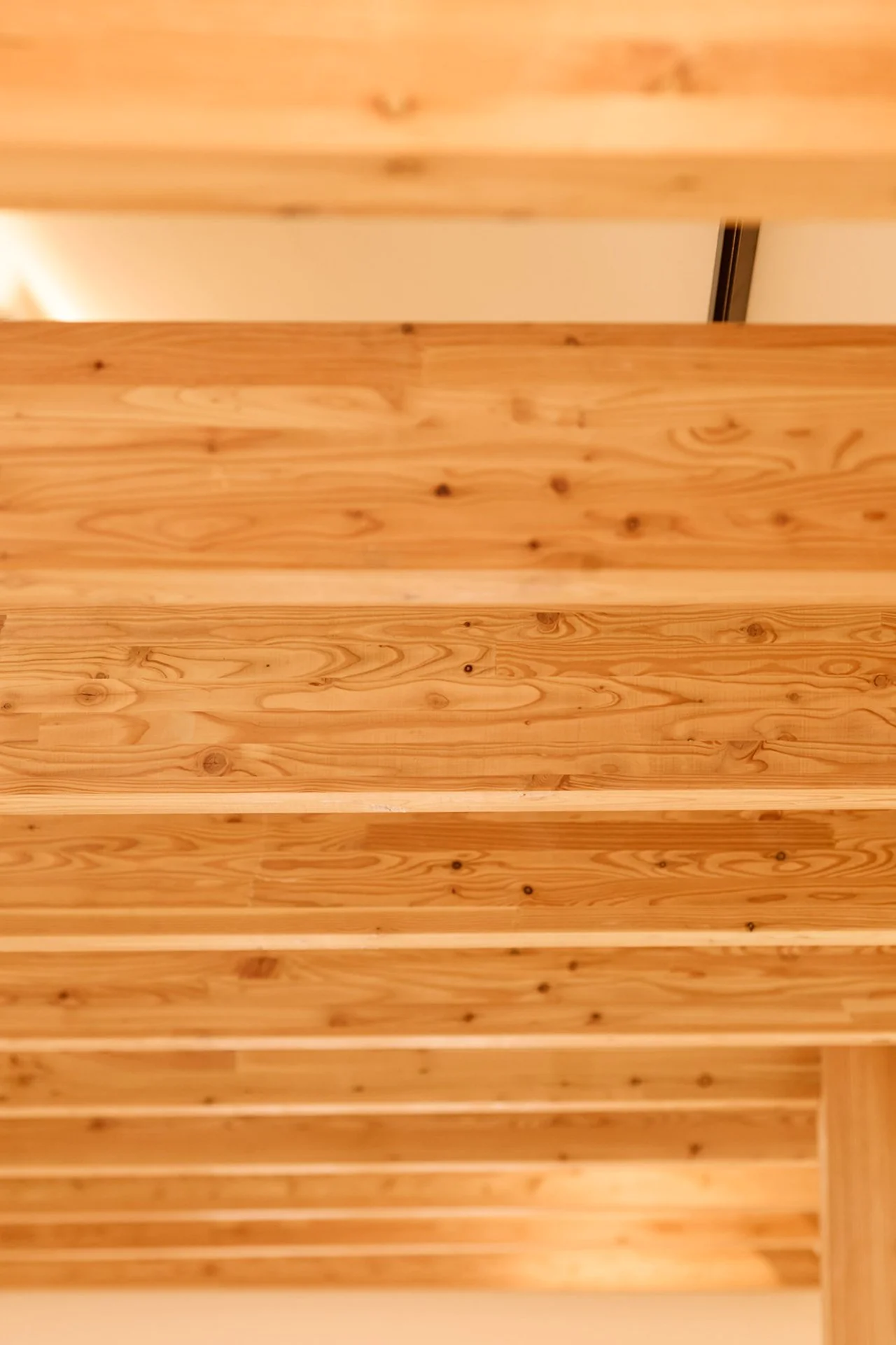 Holzdecke mit sichtbaren Holzbohlen und Metallstützen.