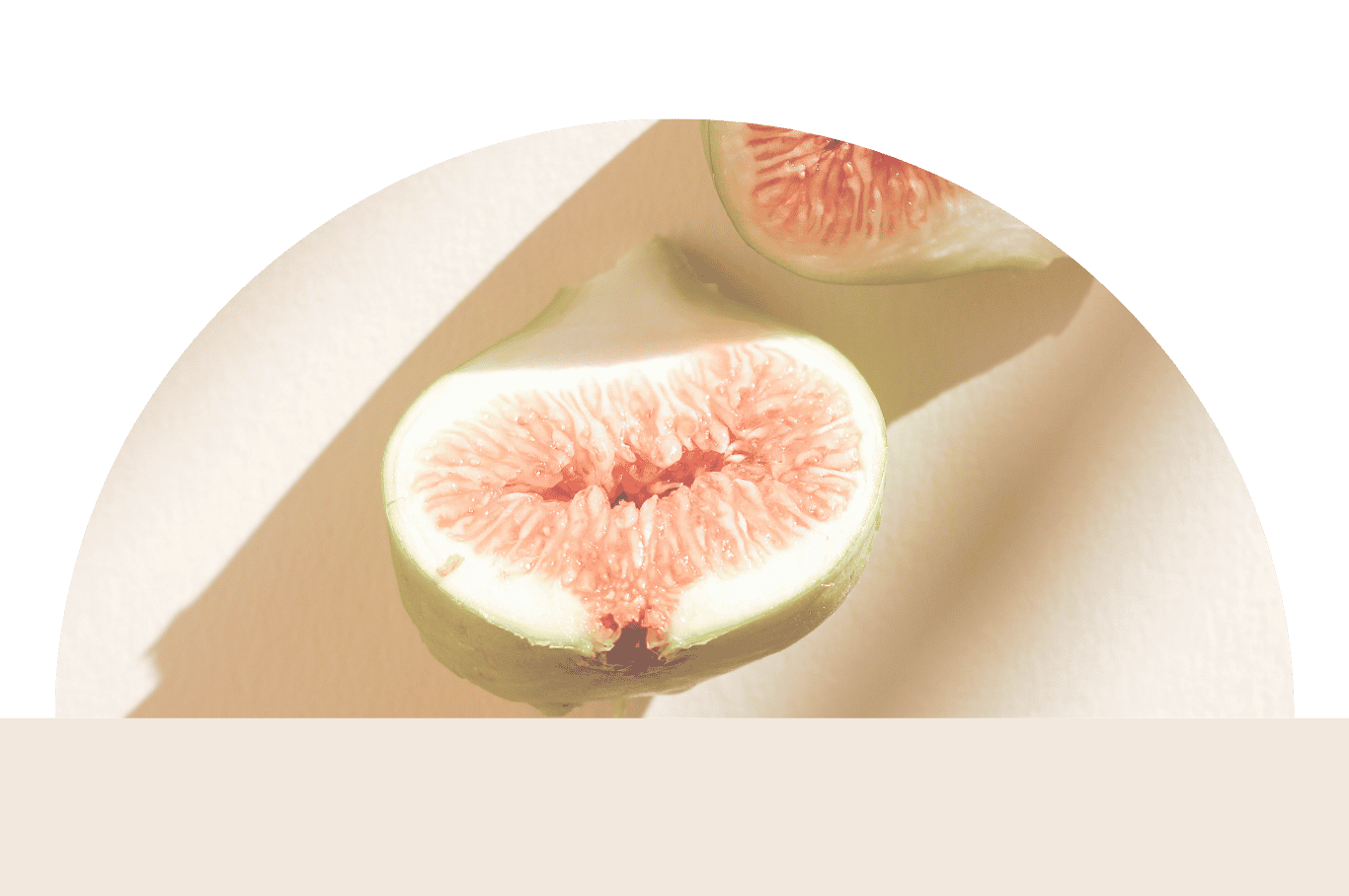 Schnitt einer grünen Kiwi mit rosa Fruchtfleisch und kleinen schwarzen Samen auf beigem Hintergrund.