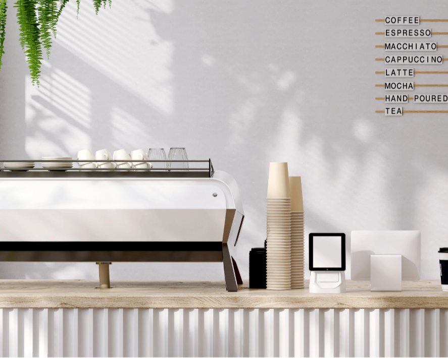 Coffee shop counter with a coffee machine, paper cups, a digital order display, and a menu on the wall listing coffee options like espresso, macchiato, cappuccino, latte, mocha, hand-poured tea.