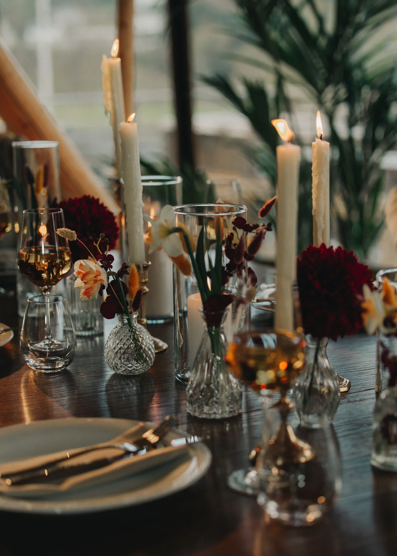 Elegant borddekking med lysende stearinlys, blomster og glass med vin. Praktfull bordsetting for en spesiell anledning.