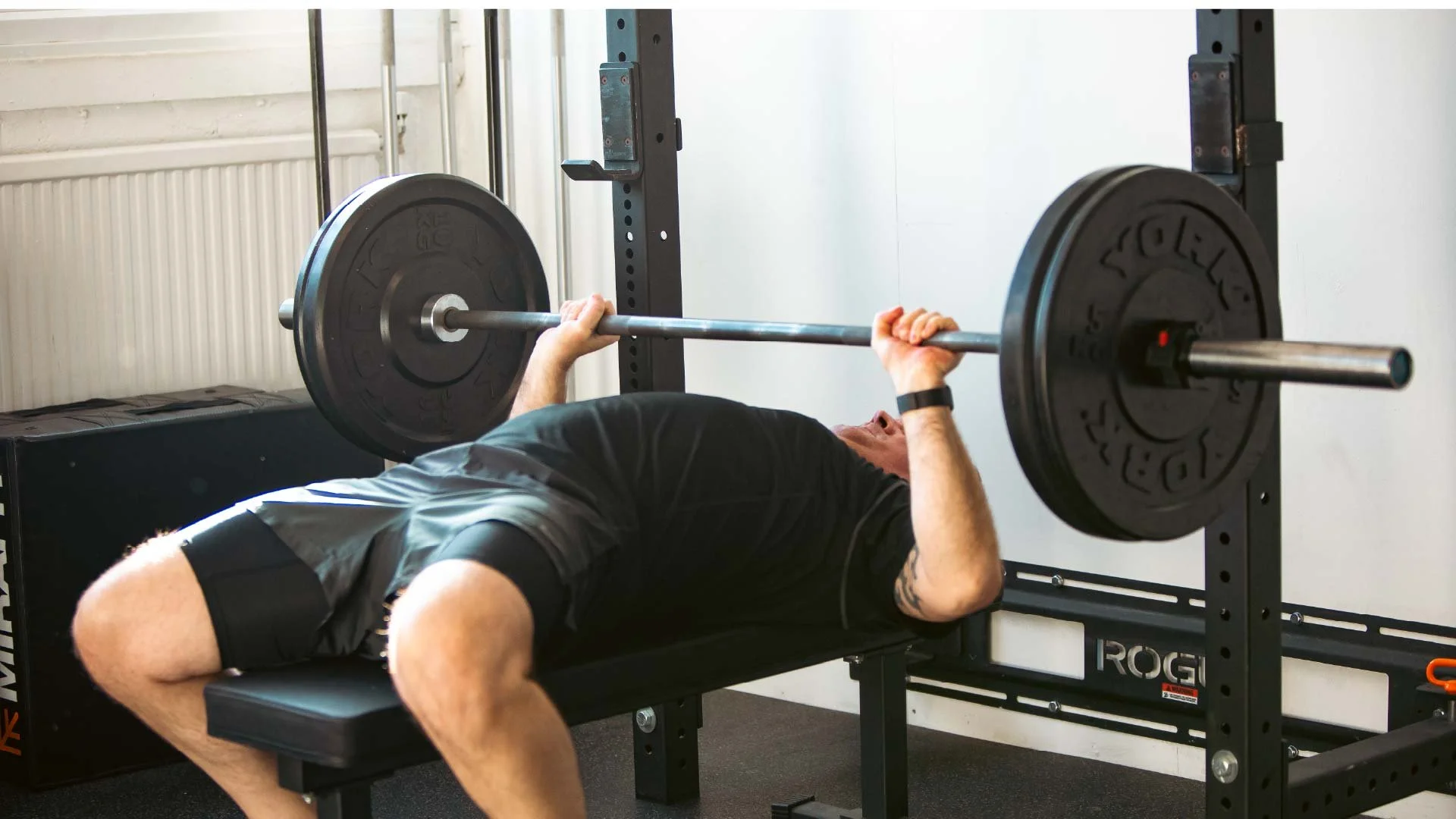 BUILT Training member performing a barbell bench press