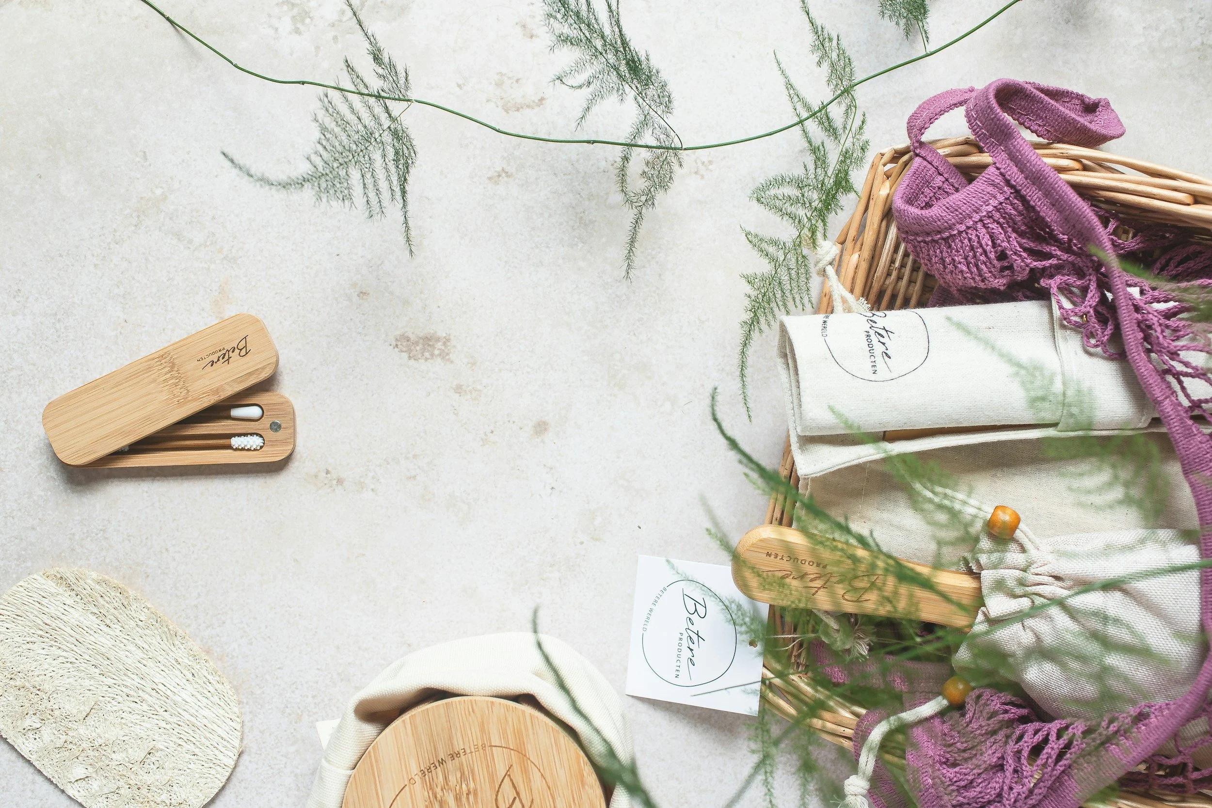 Reusable cotton and mesh bags with bamboo utensils and greenery
