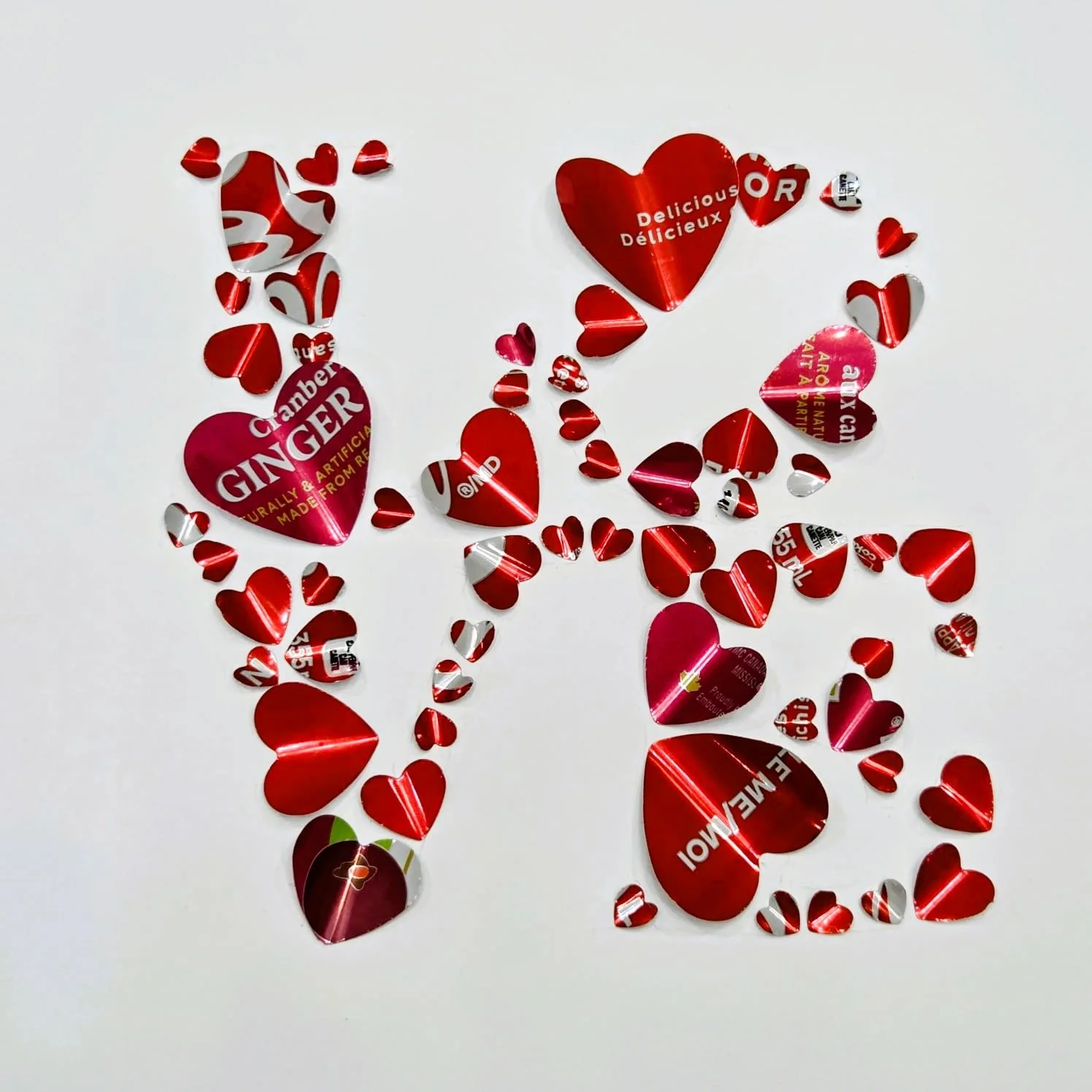 Heart-shaped and small heart-shaped foil wrappers scattered on a white surface.