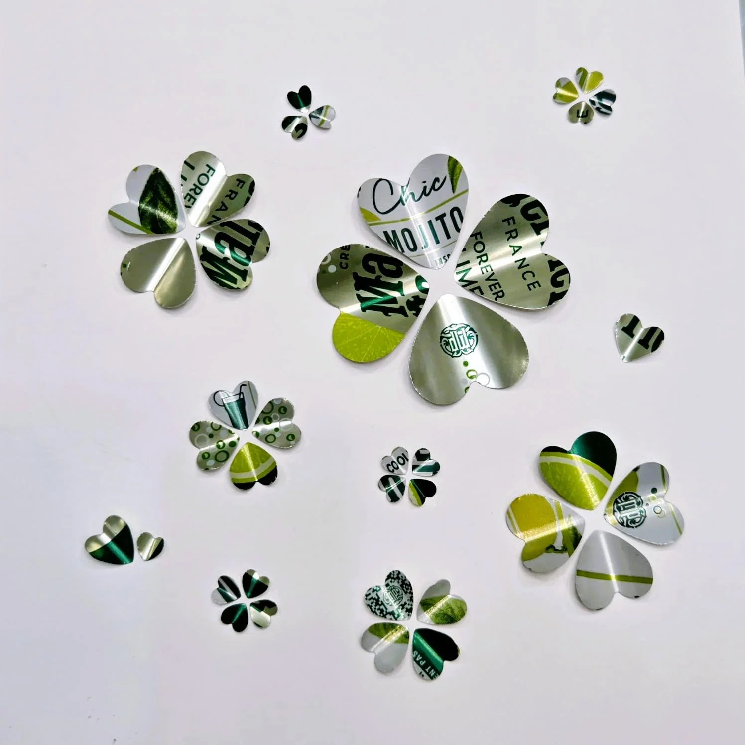 Collection of decorative paper shamrock cutouts on a white background, with various colors and patterns.