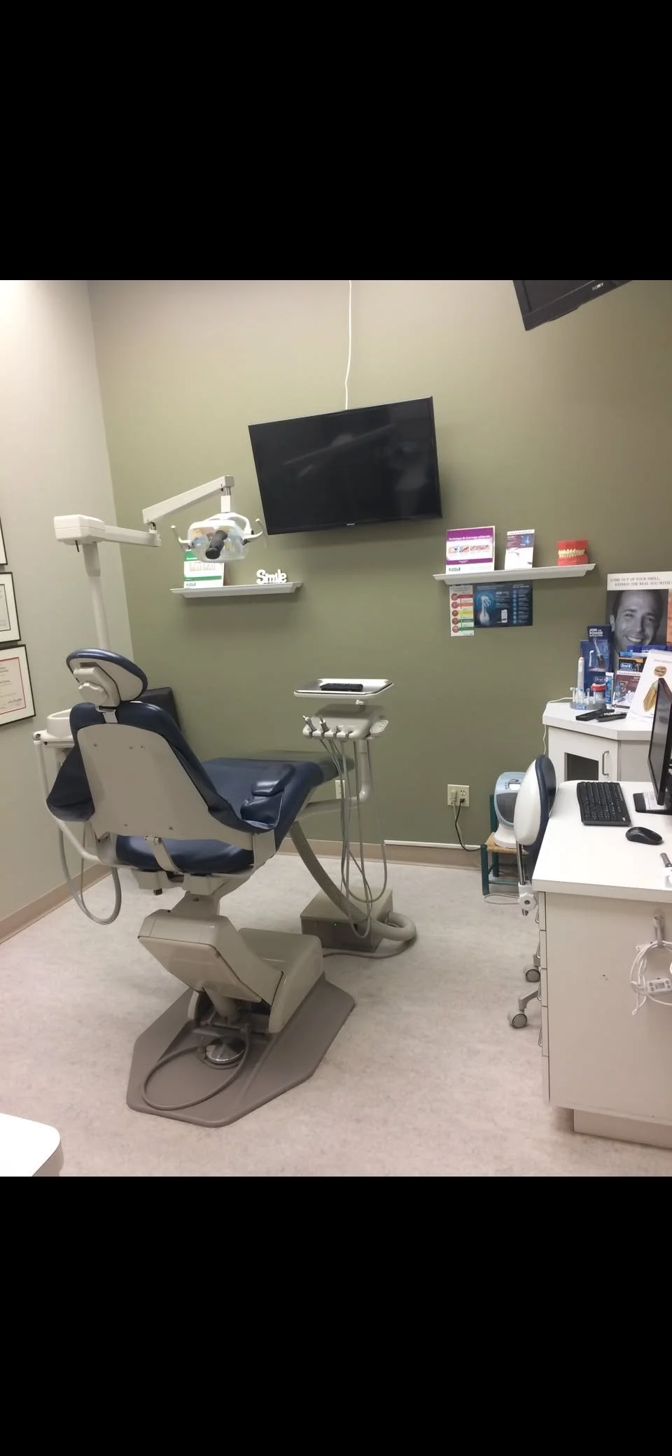 Dental office with dental chair, dental tools, monitors, and educational materials