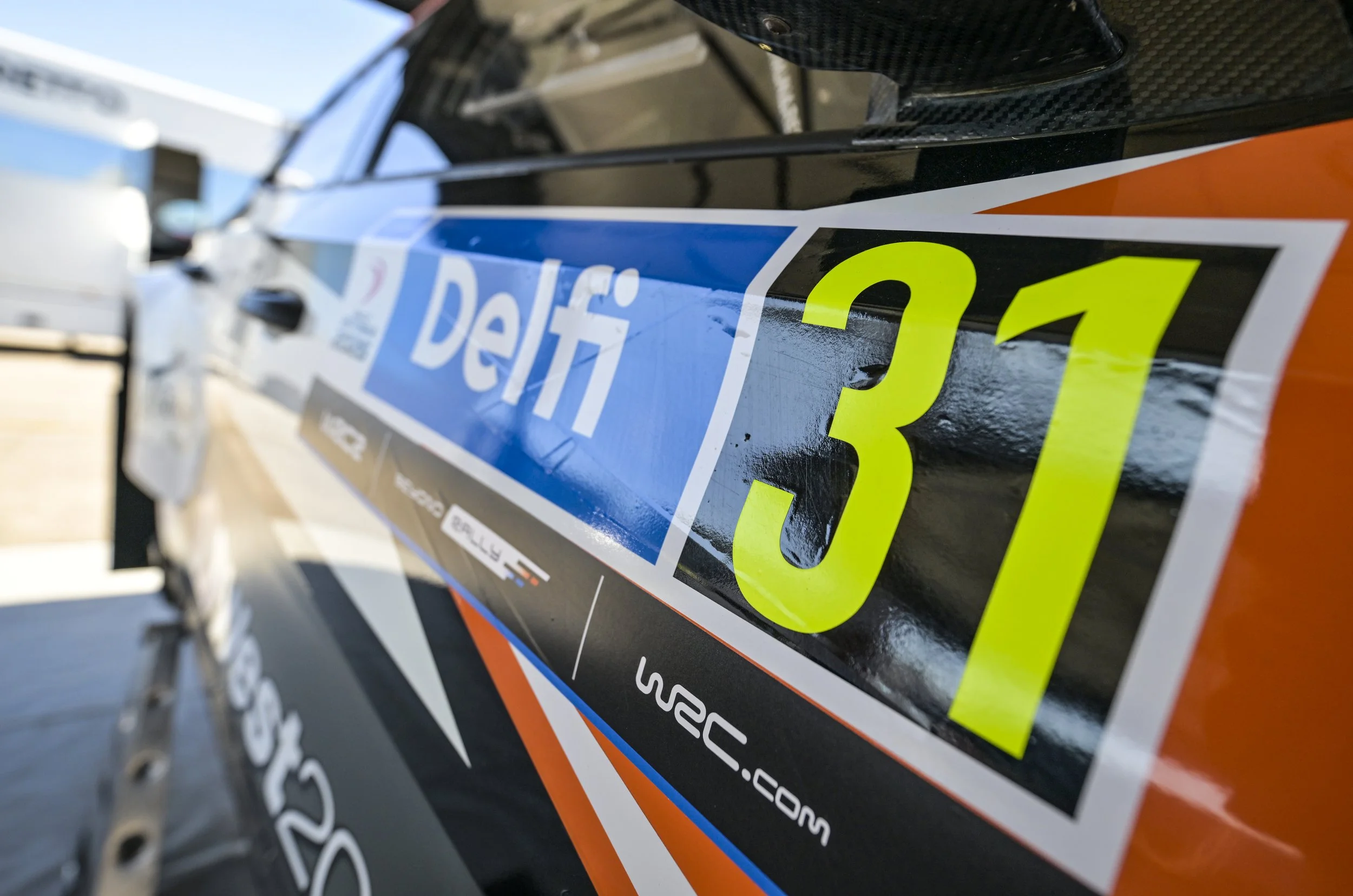 Close-up of a race car with the number 31 and sponsor logos, showing a focus on the decals and surface details.