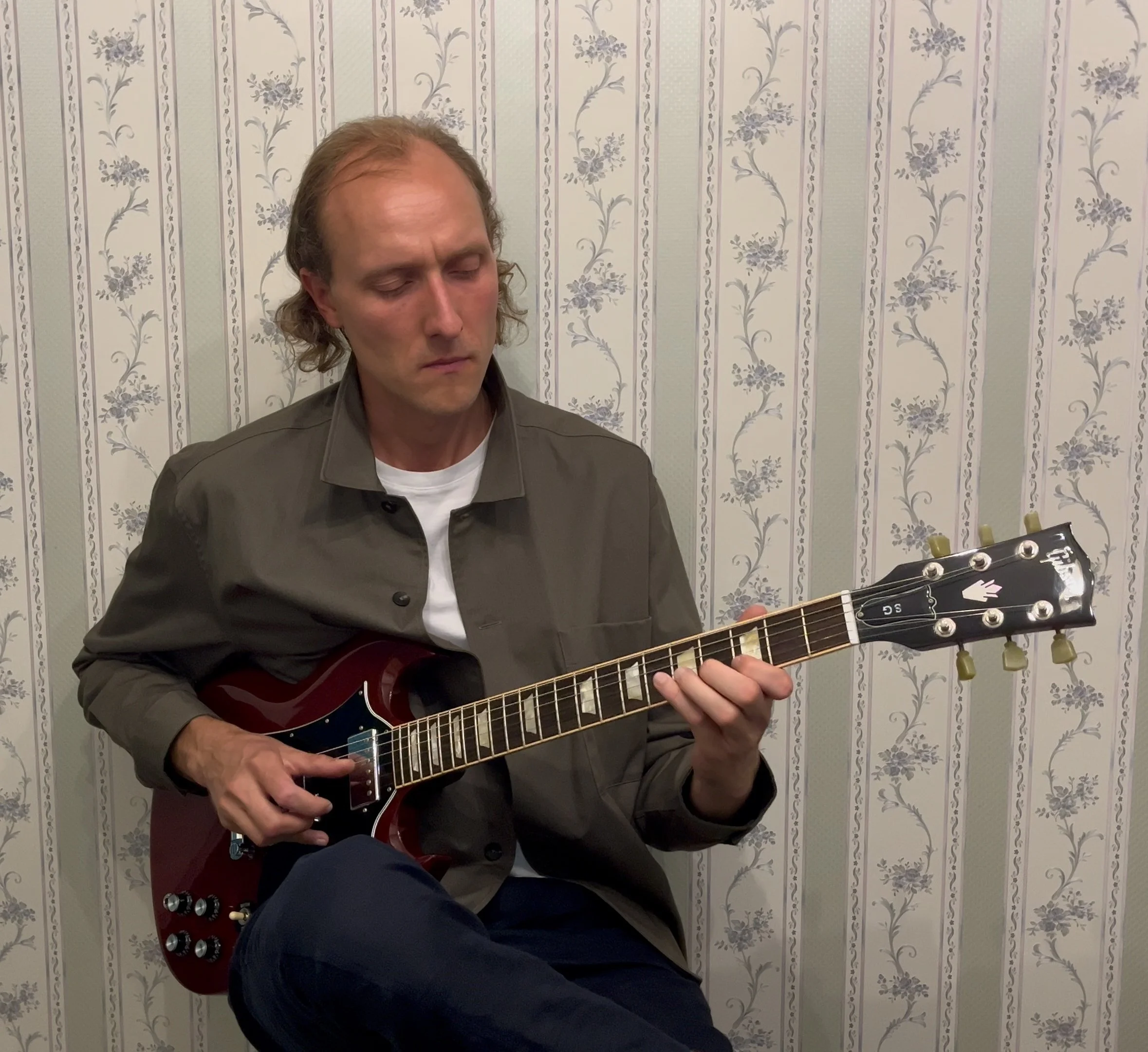 Gitaros mokytojas groja Gibson SG elektrine gitara individualios elektrinės gitaros pamokos metu