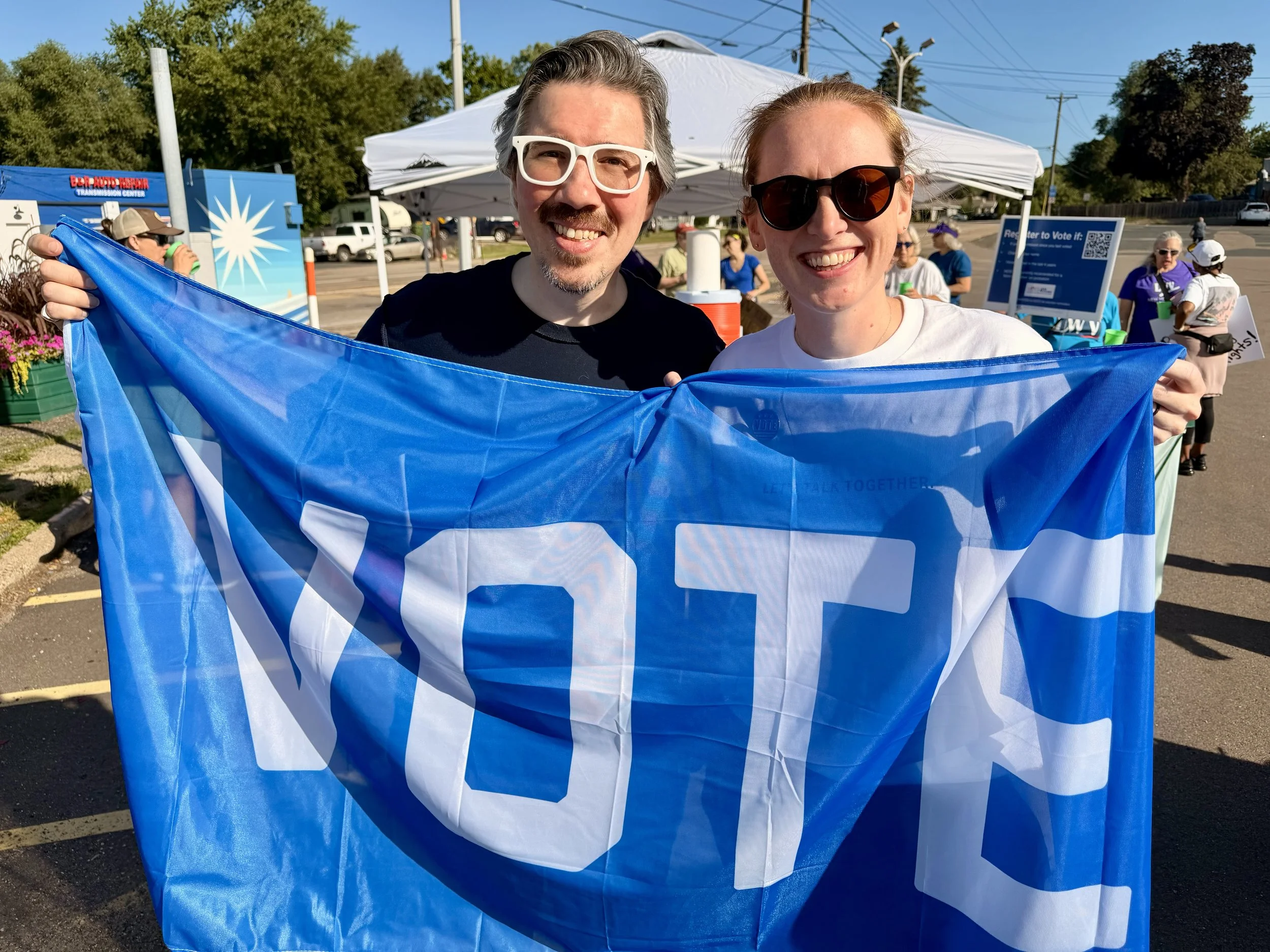 Coryell and Ray holding a VOTE flag