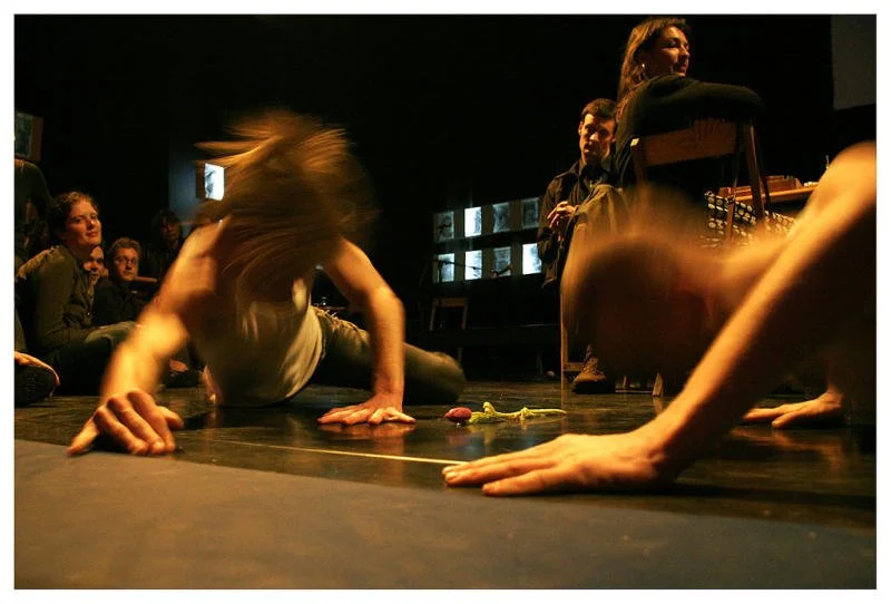 People performing on stage with some seated audience members in the background