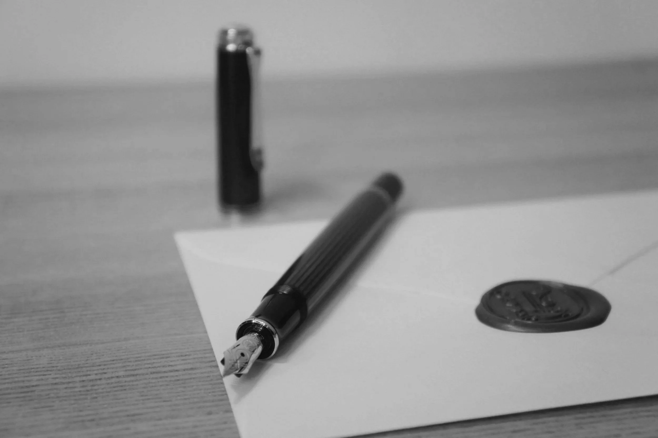 Ein Kugelschreiber, ein Filzstift und ein Radierer liegen auf einem Papier auf einem Tisch.
