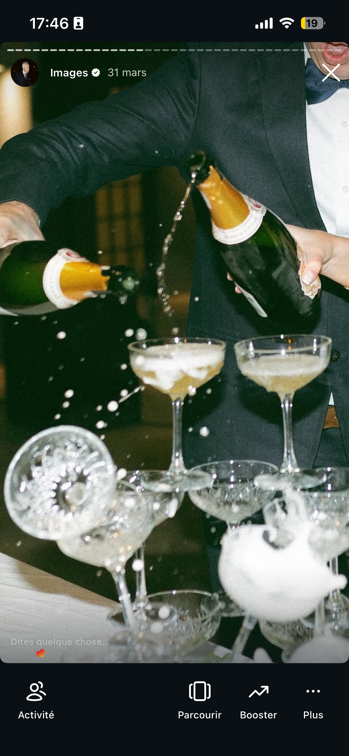 Une personne en costume verse de la champagne dans des coupes à champagne lors d'une célébration.