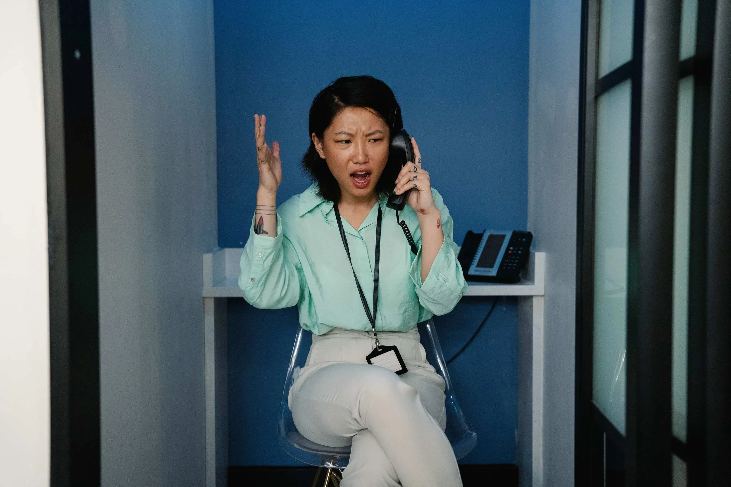 Frustrated office receptionist on a phone call at a busy desk