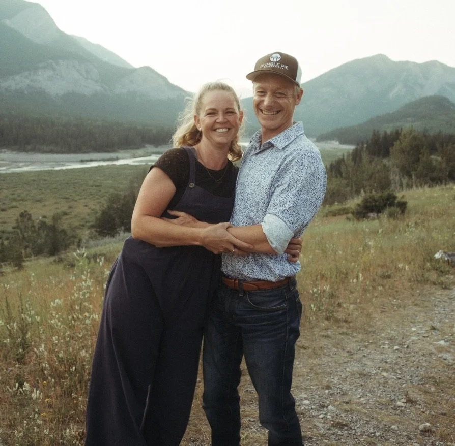 Natalie Winters, founder of Humble Pie Promotions, with Dean Winters filming a wedding with mountains and a river in the background.