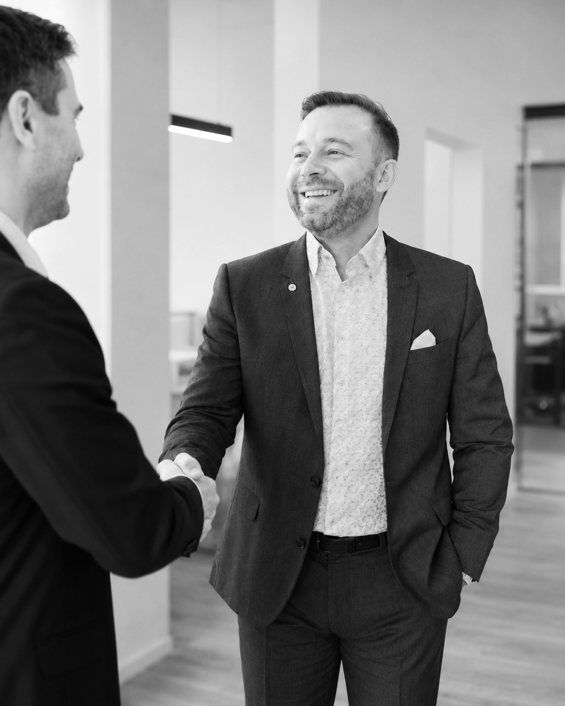 Christian Bolz von der Contur Schadenmanagement GmbH schüttelt die Hand, lächeln und haben eine freundliche Unterhaltung in einem modernen Büro.