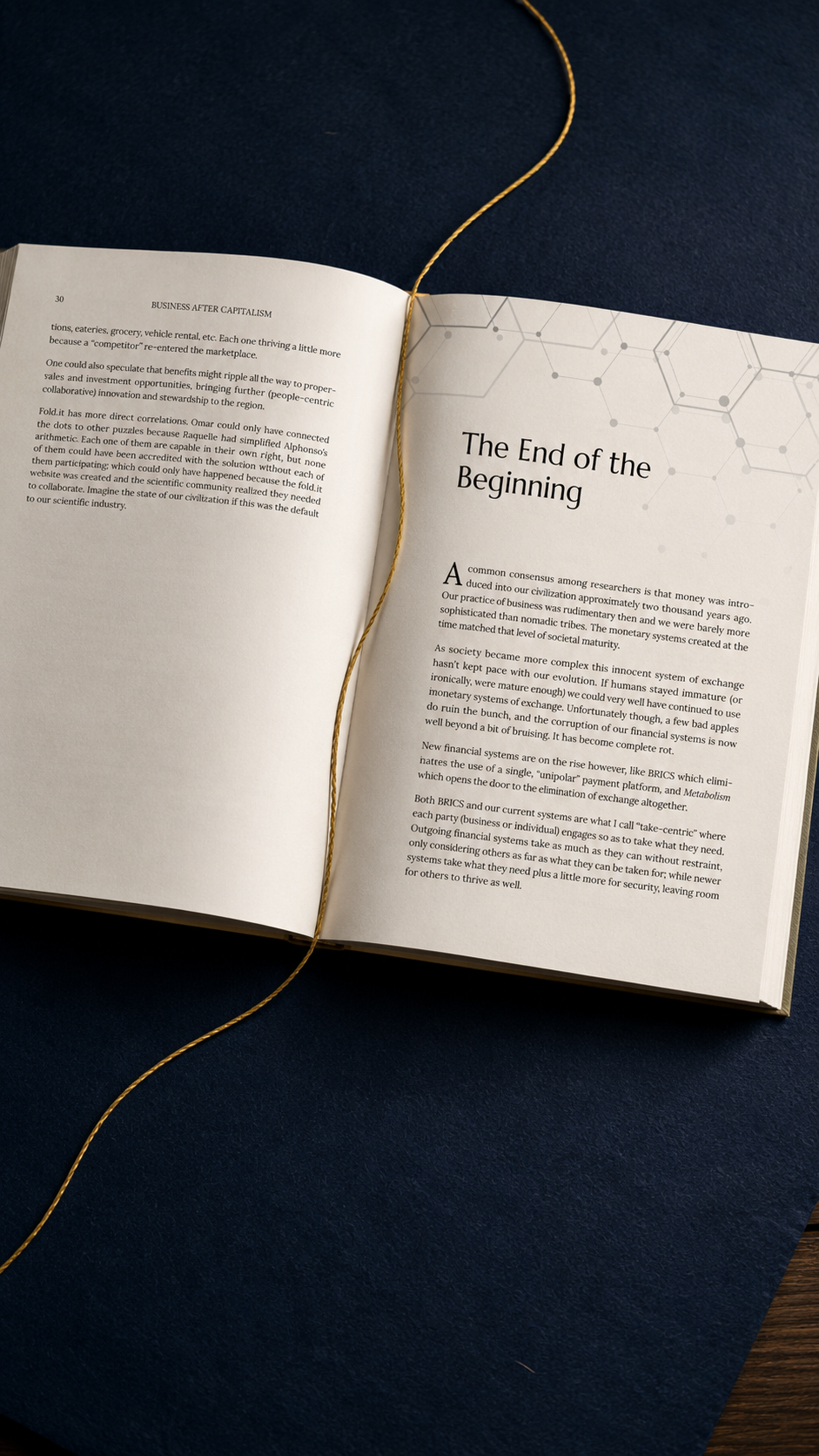Open book with text titled 'The End of the Beginning', sitting on dark blue surface with a gold string bookmark.