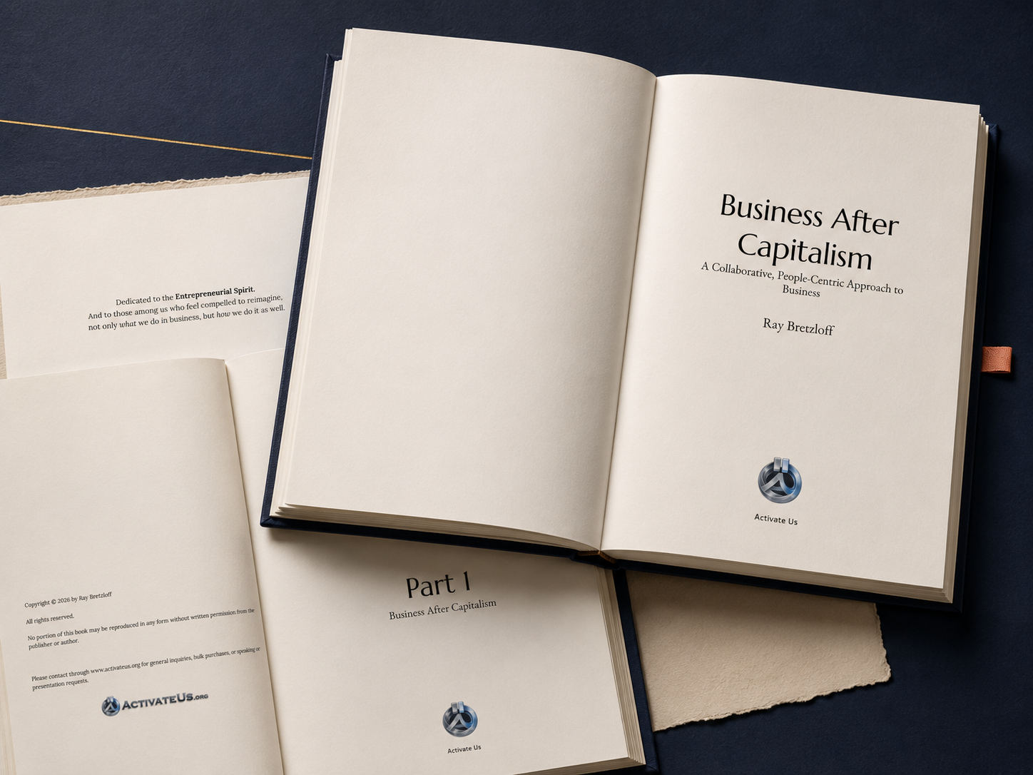 Open book titled 'Business After Capitalism' by Ray Bretzloff, published by Activate Us, on a dark background, with another open book and papers nearby.