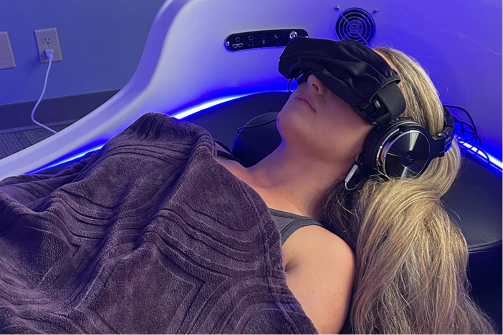Person experiencing rhythmic light frequencies as part of the NeuroReset multi-sensory system