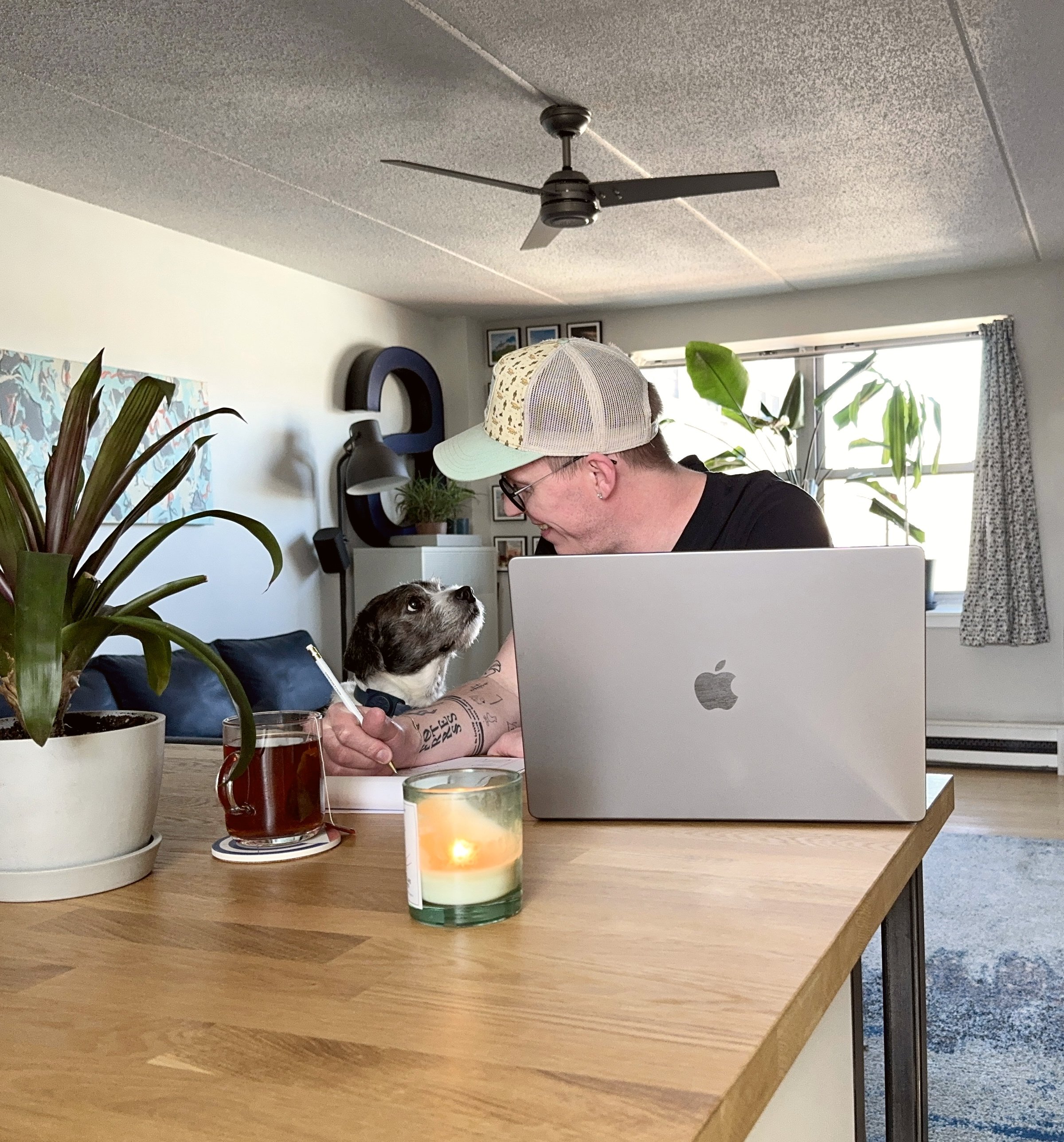 Cole working at his laptop at home with his dog