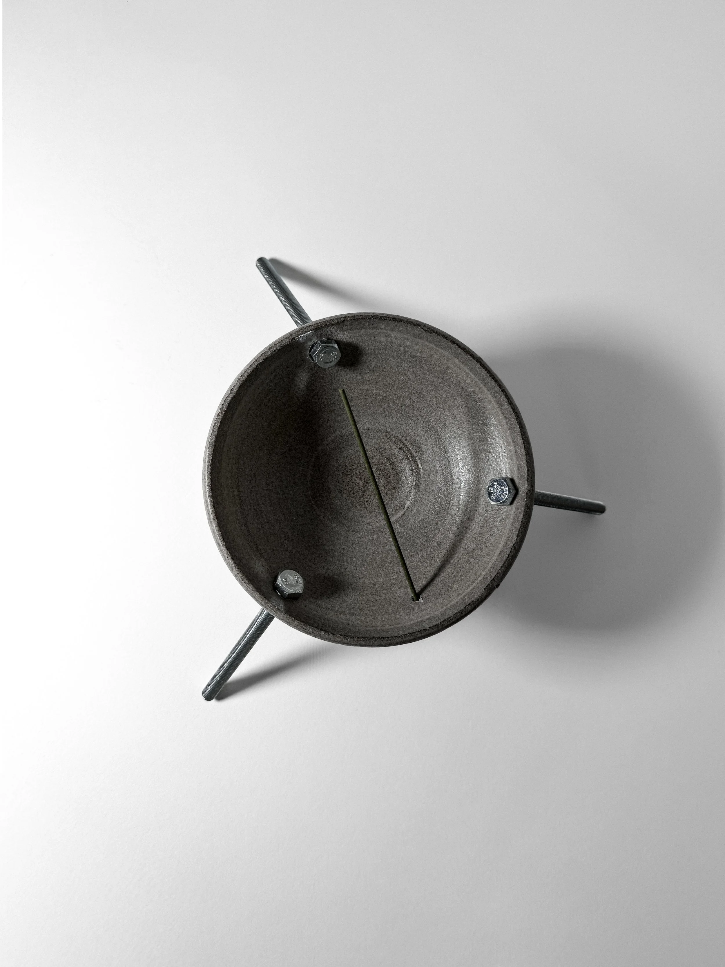 brutalist ritual 01 incense holder seen from above, grey stoneware dish on three stainless steel rods
