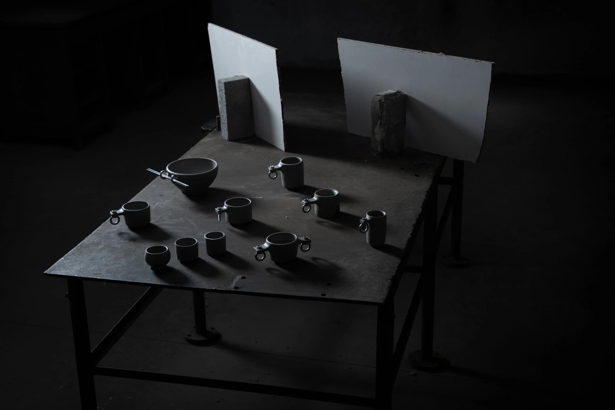 brutalist stoneware cups and bowl with steel hardware displayed on a steel table, The Brutalist Issue 01 launch