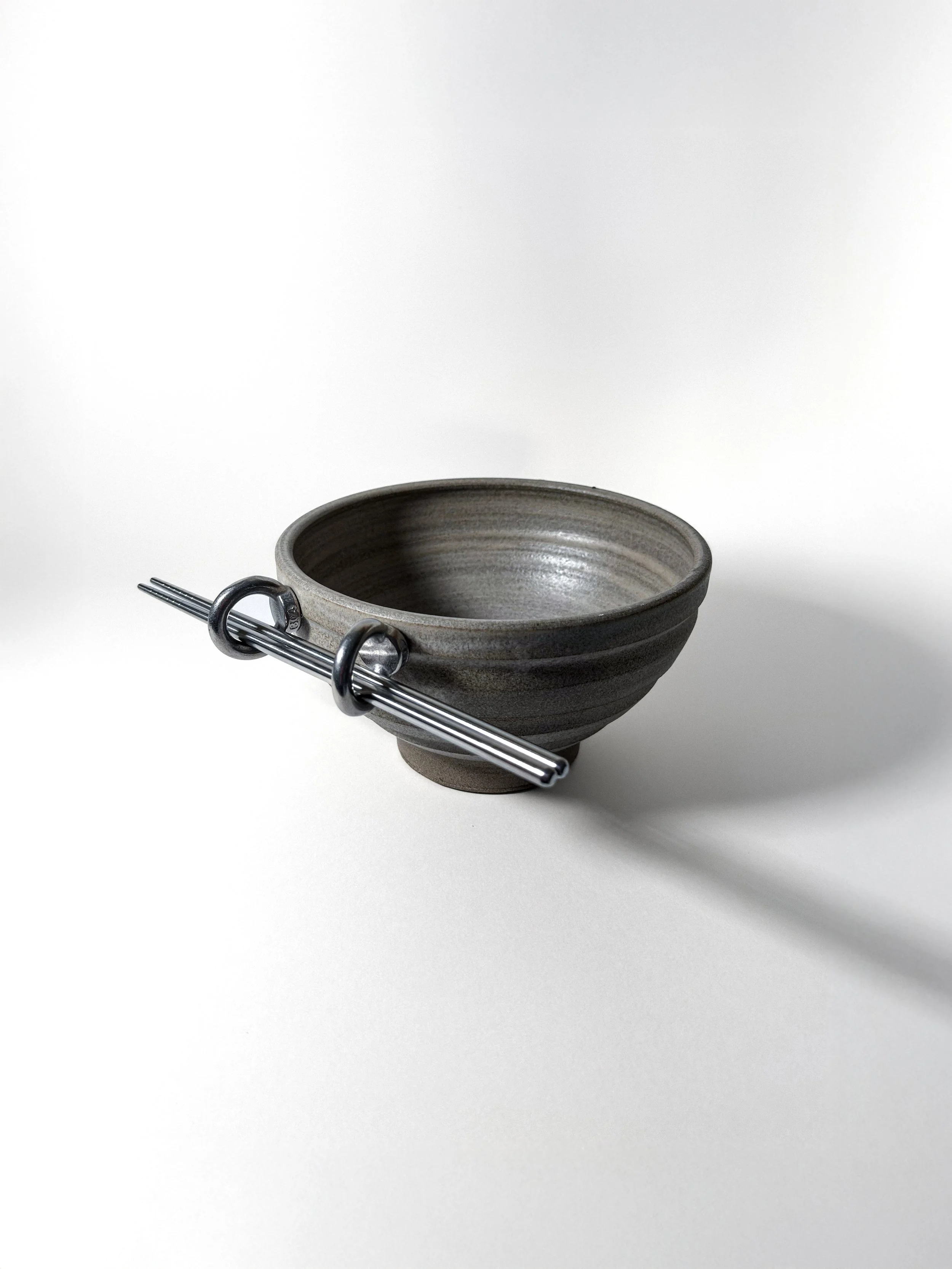 beton bowl handmade stoneware bowl with eye-bolt loops used as chopstick rests, side view